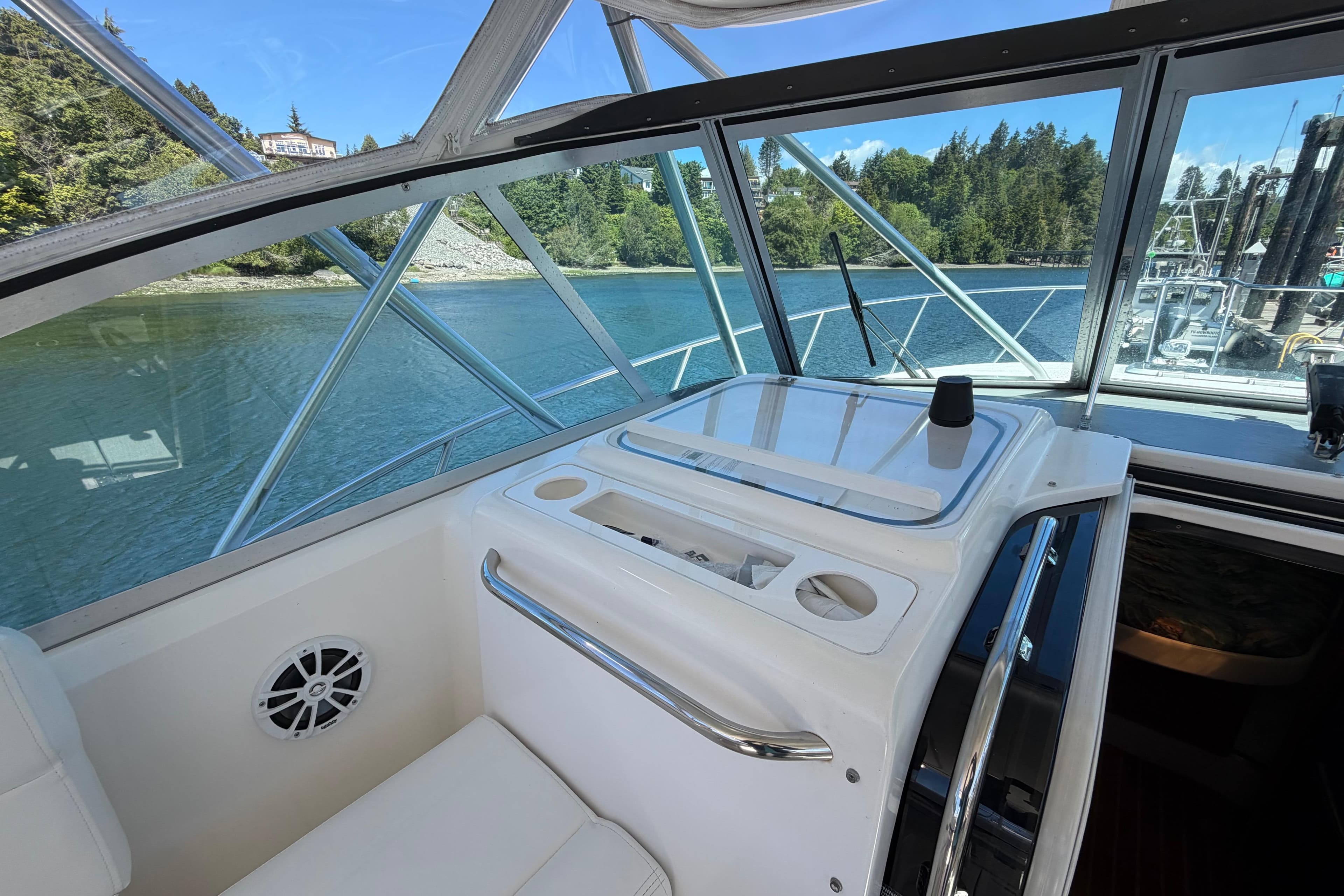 Interior view of a 2000 Pursuit 3400 Express boat with scenic waterway backdrop.