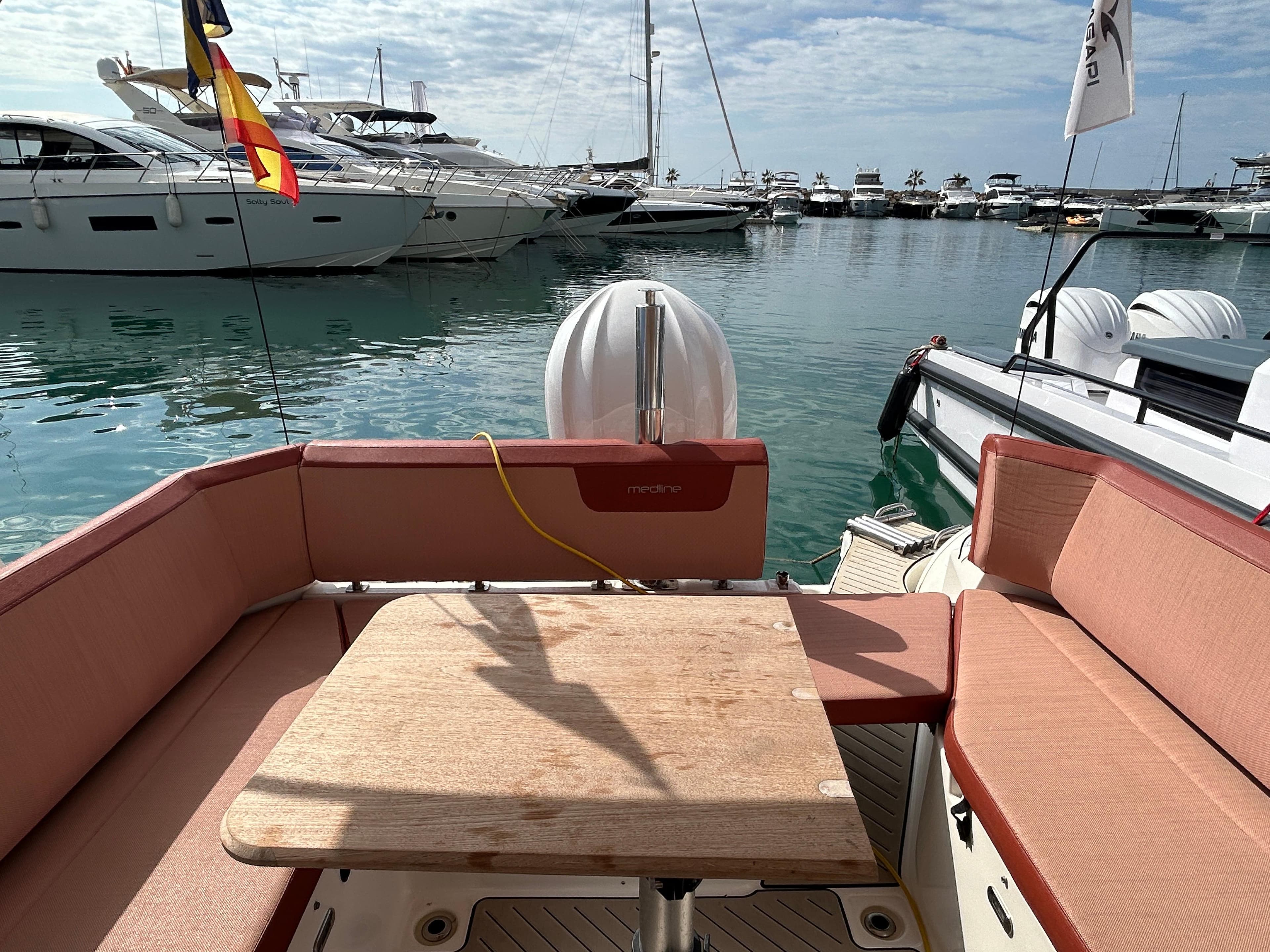 2021 Zodiac Medline 9 boat interior with seating and table, docked in a marina.