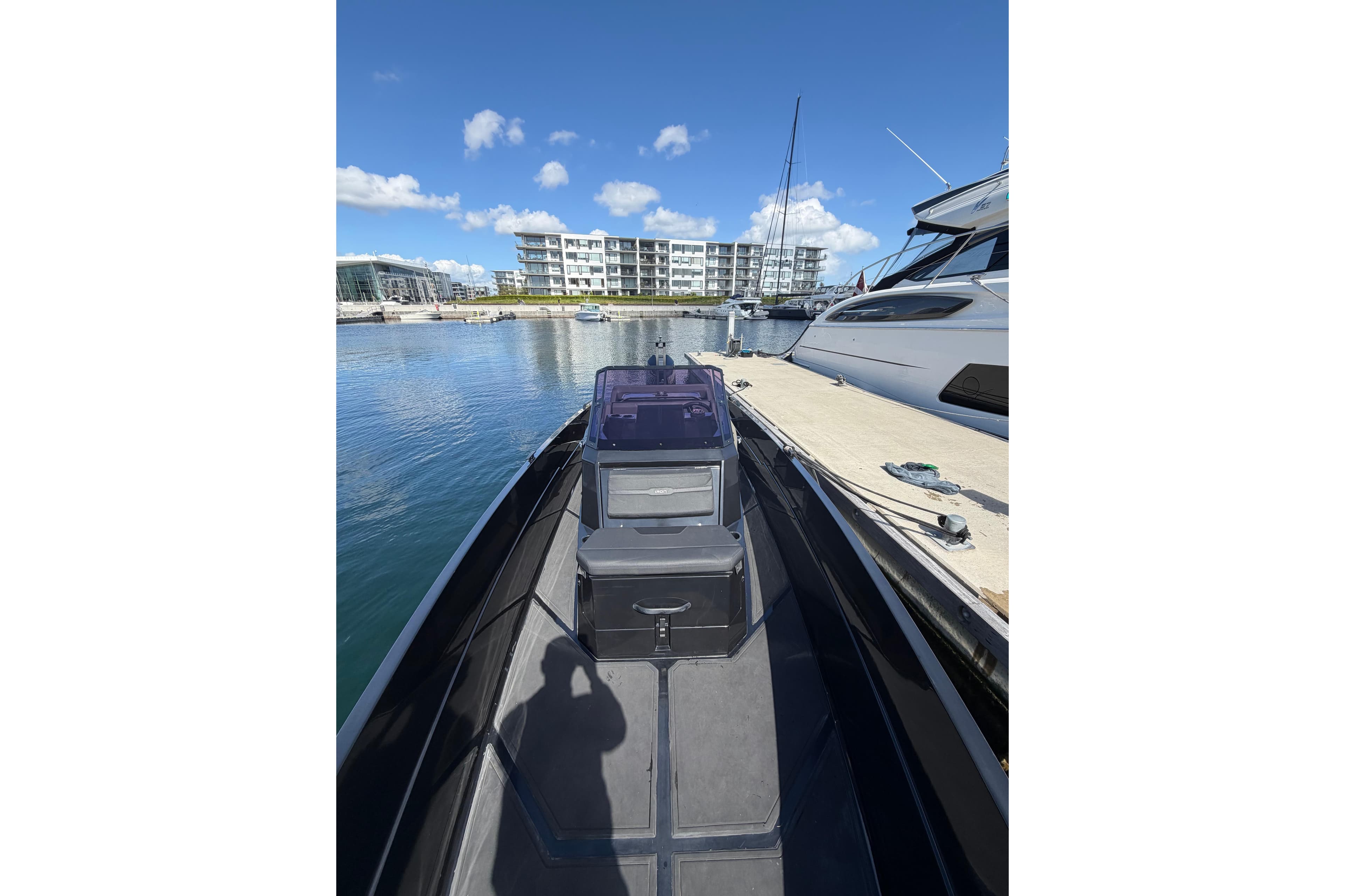 Modern Iron 827R boat docked at marina, 2022 model, with waterfront buildings in background.