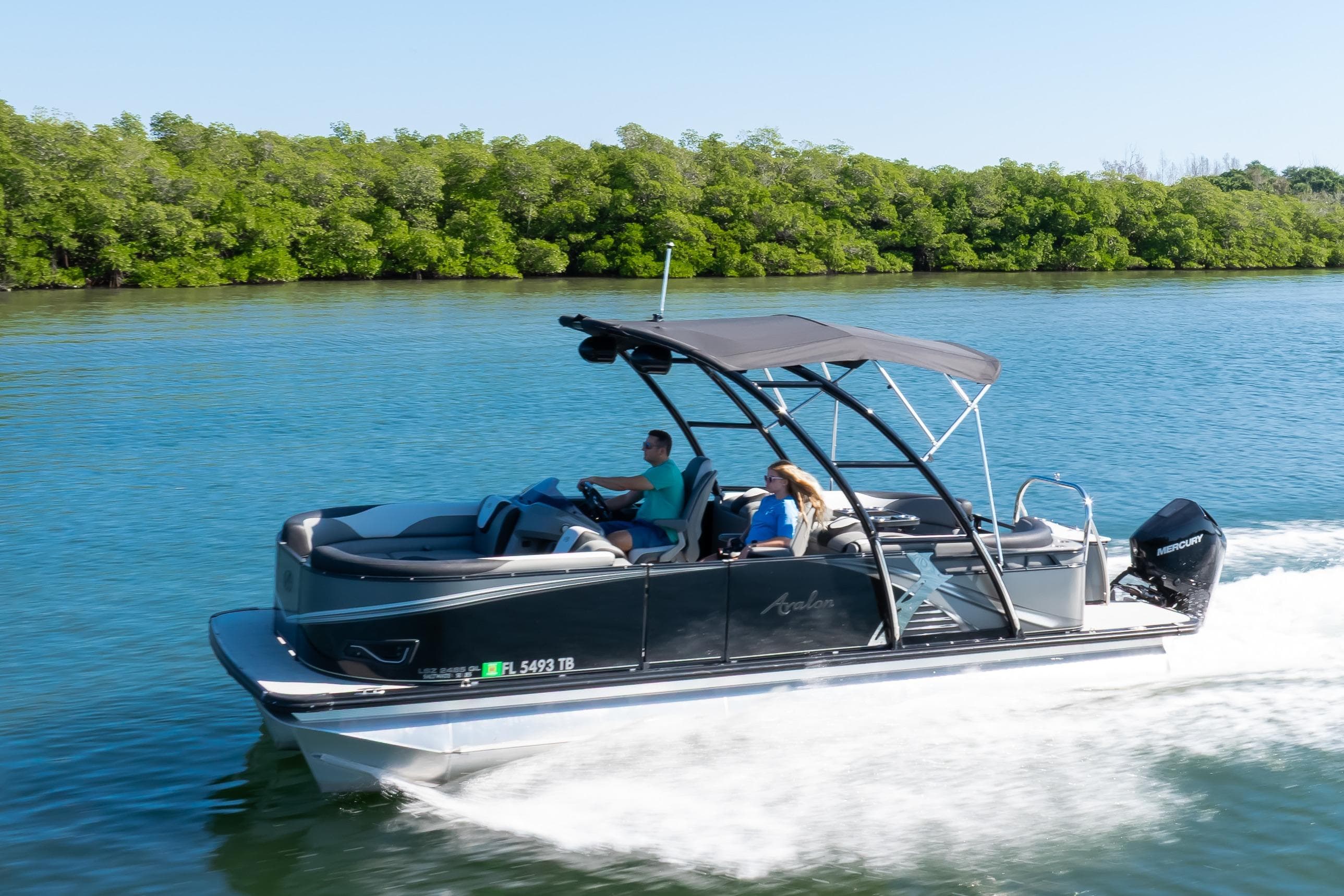 2021 Avalon LSZ Quad Lounger 24' pontoon boat cruising on a scenic waterway.