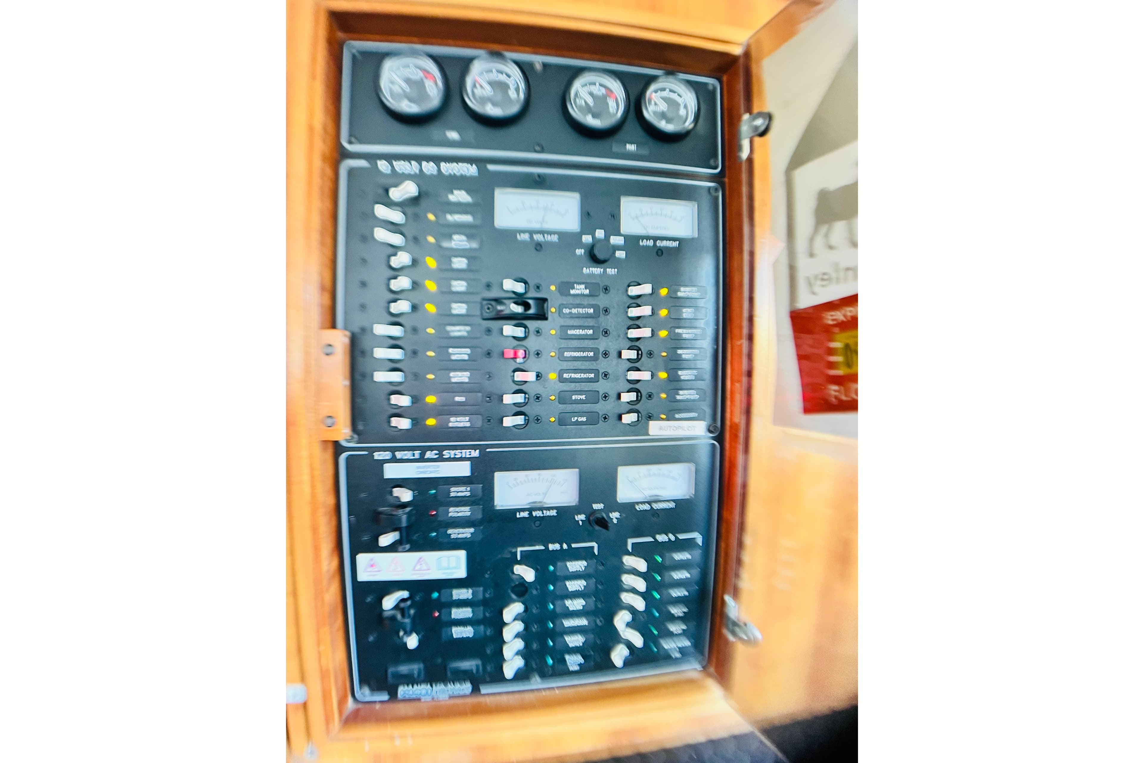 Electrical control panel on a 2007 PDQ MV41 boat, featuring gauges and switches.