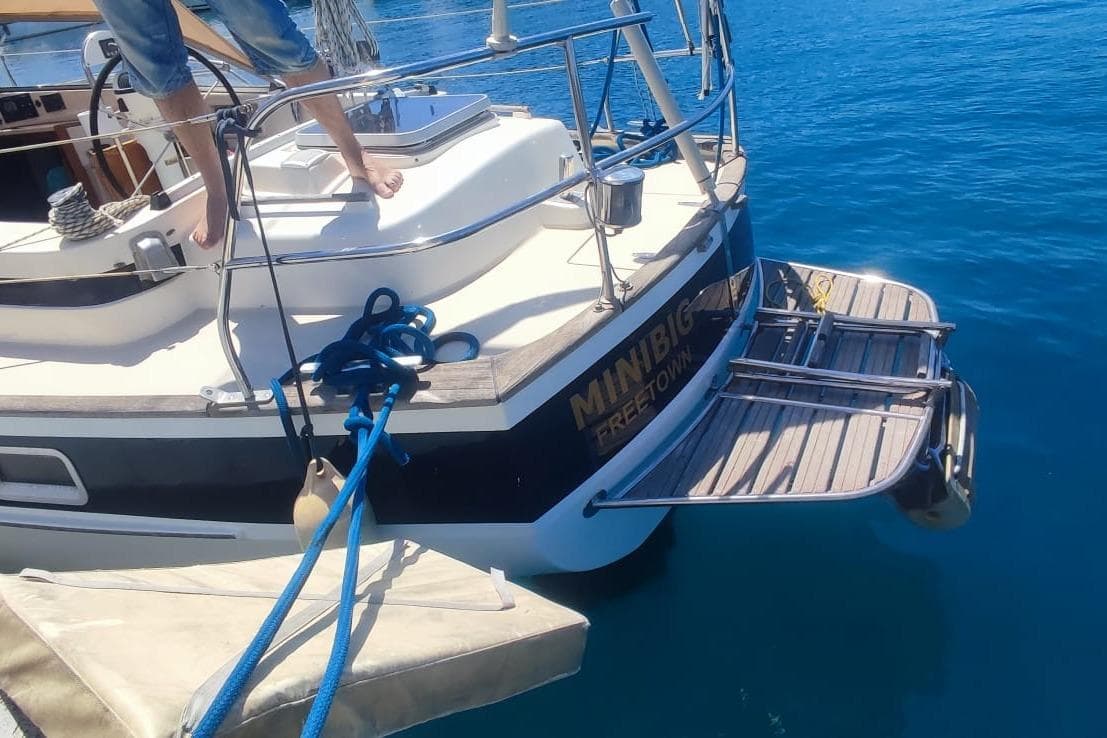 1982 Hallberg-Rassy 352 sailboat stern with swim platform on clear blue water.