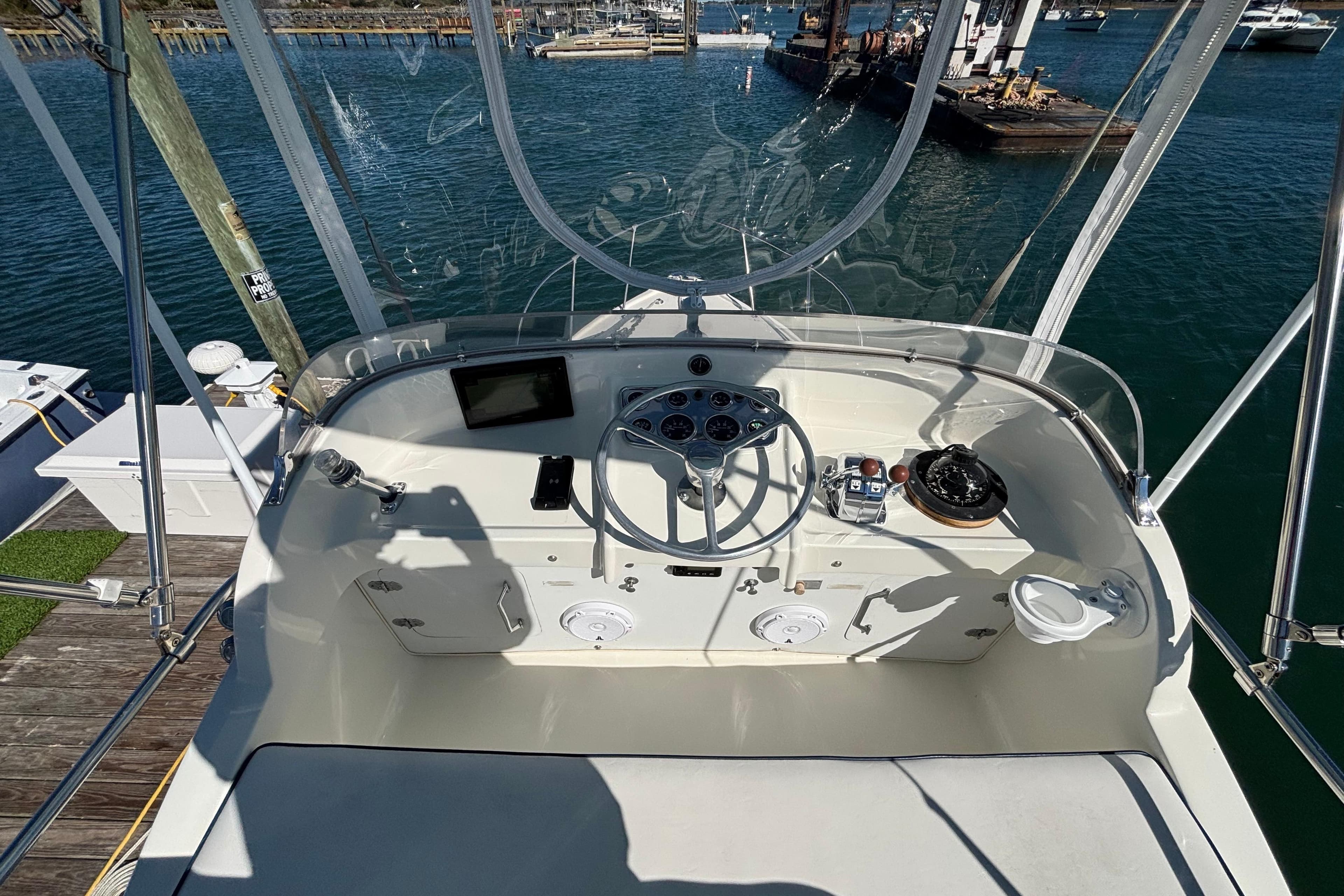 1970 Bertram 31 Flybridge Cruiser helm with steering wheel, gauges, and navigation equipment.