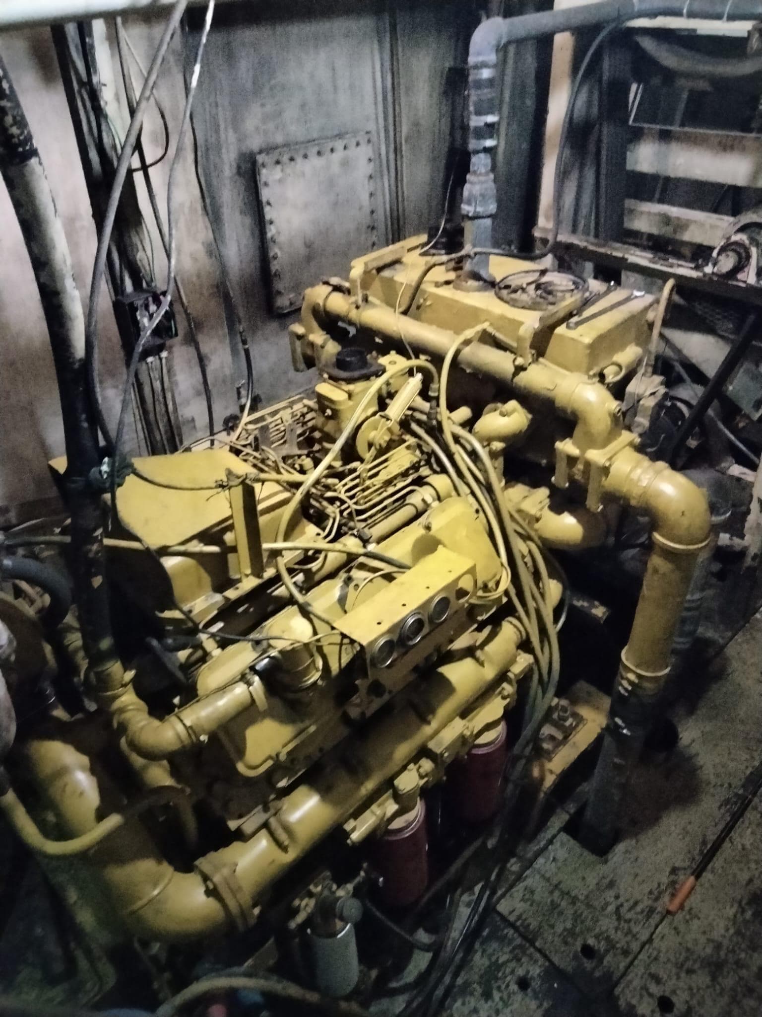 Engine room of a 1972 commercial shrimp freezer trawler, showcasing complex machinery and pipes.
