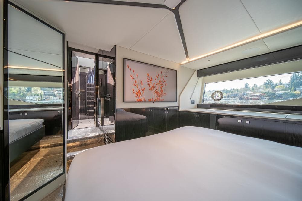 Luxurious interior of 2025 Sunseeker Predator 55 yacht bedroom with modern decor and large window.