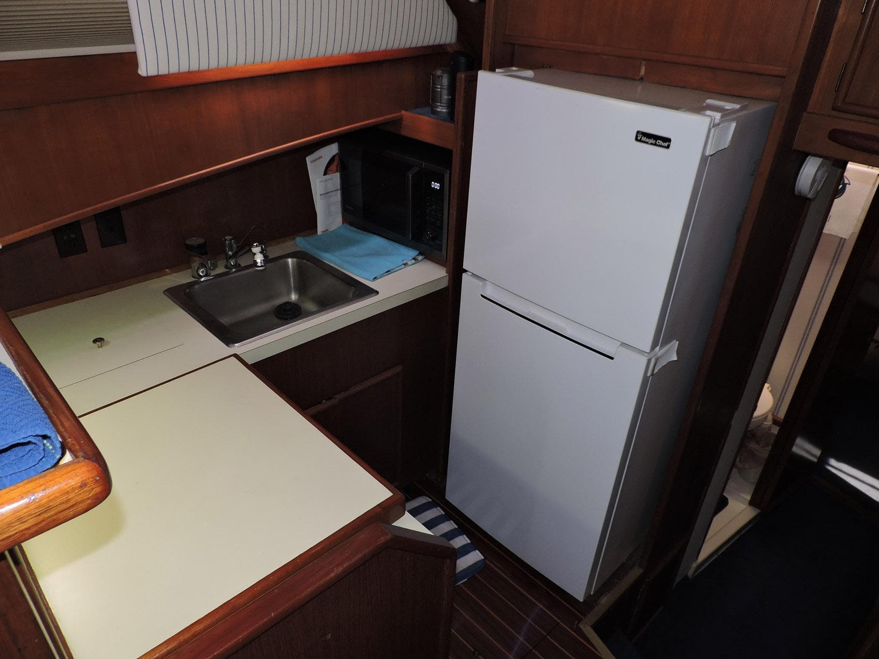 1990 Post 44 Sport Fisherman kitchen with sink, refrigerator, and microwave.