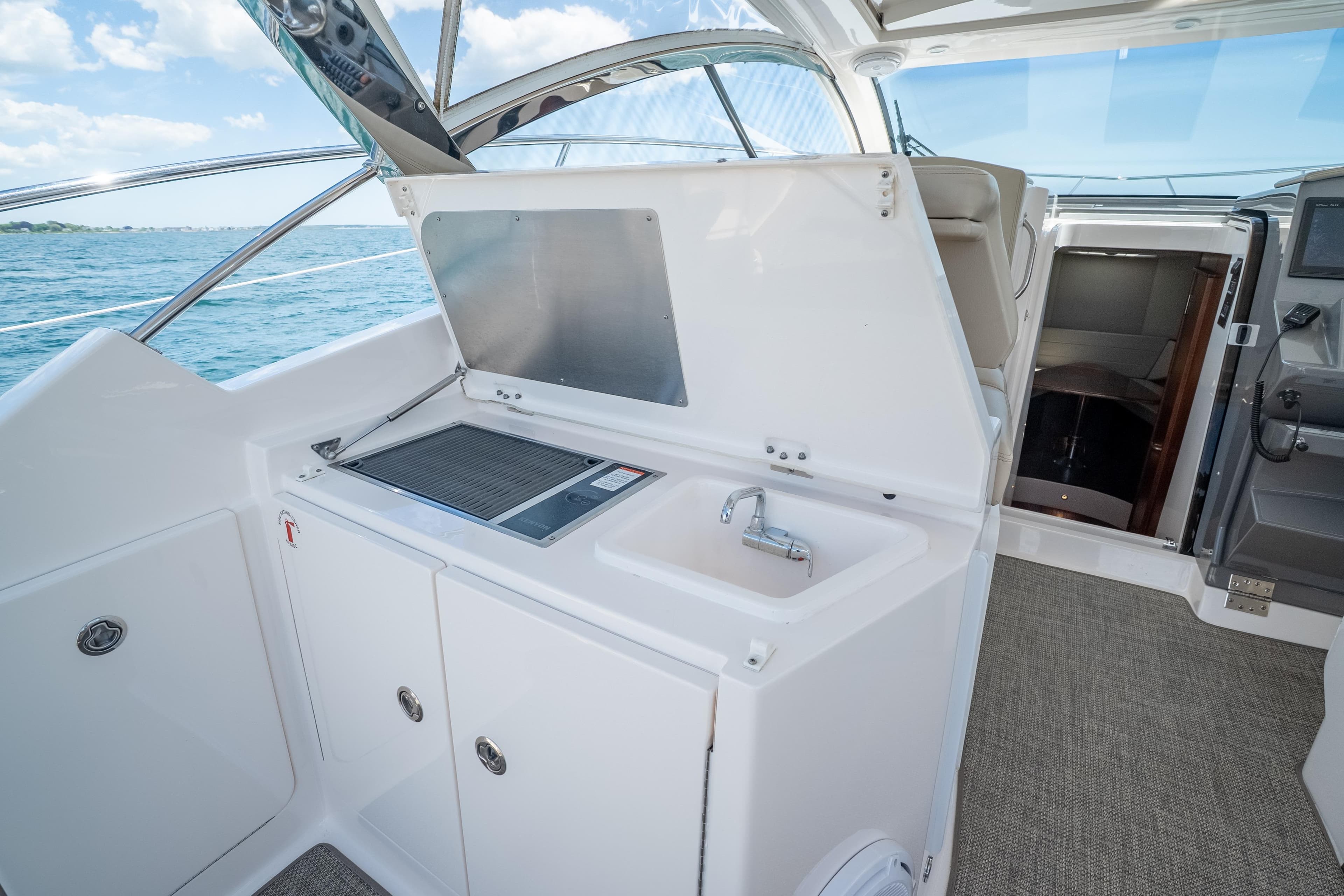 2015 Pursuit SC 365i Sport Coupe yacht interior with kitchenette and ocean view.
