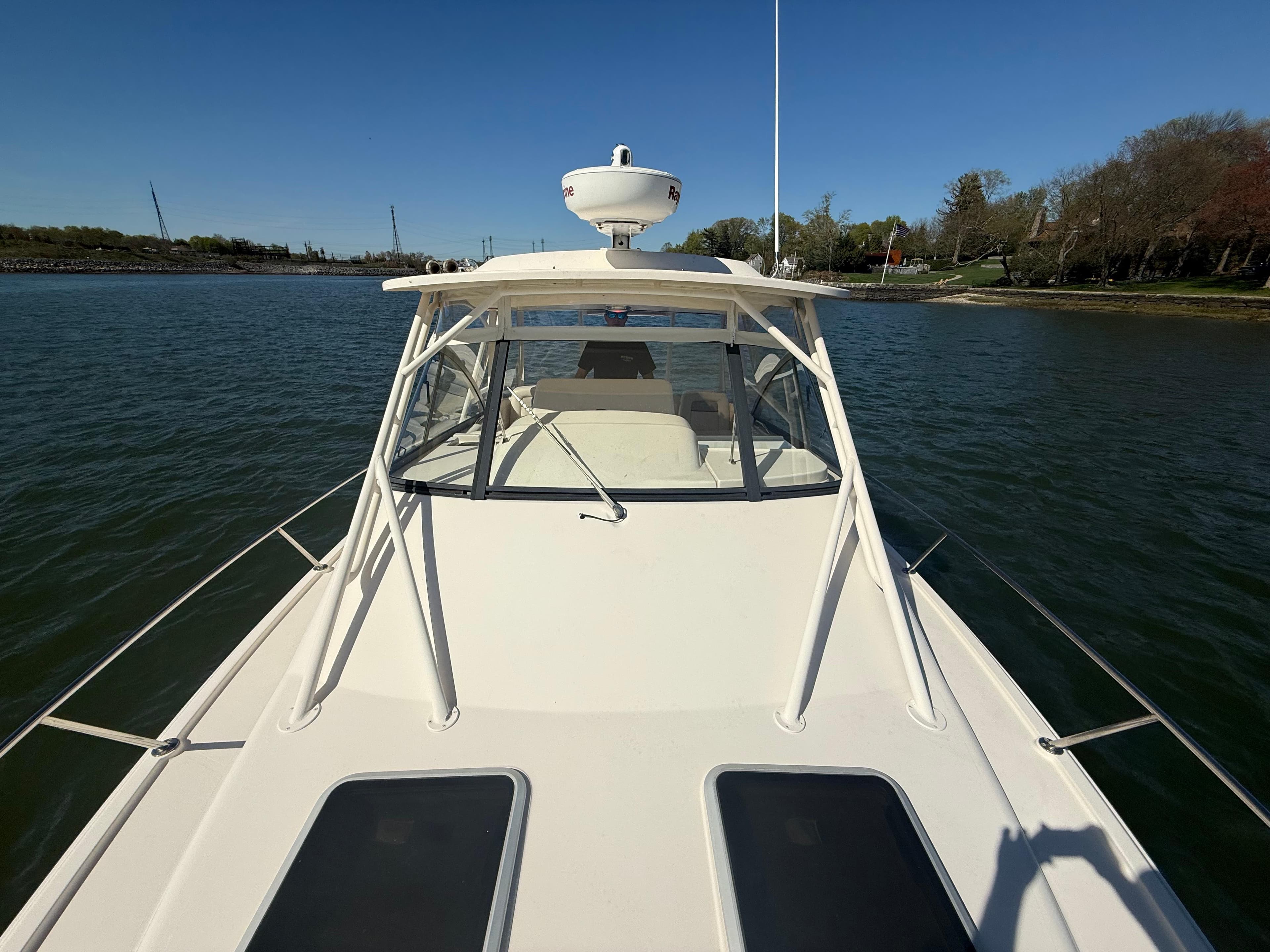 2016 Grady-White Express 330 boat on calm water, clear sky background.