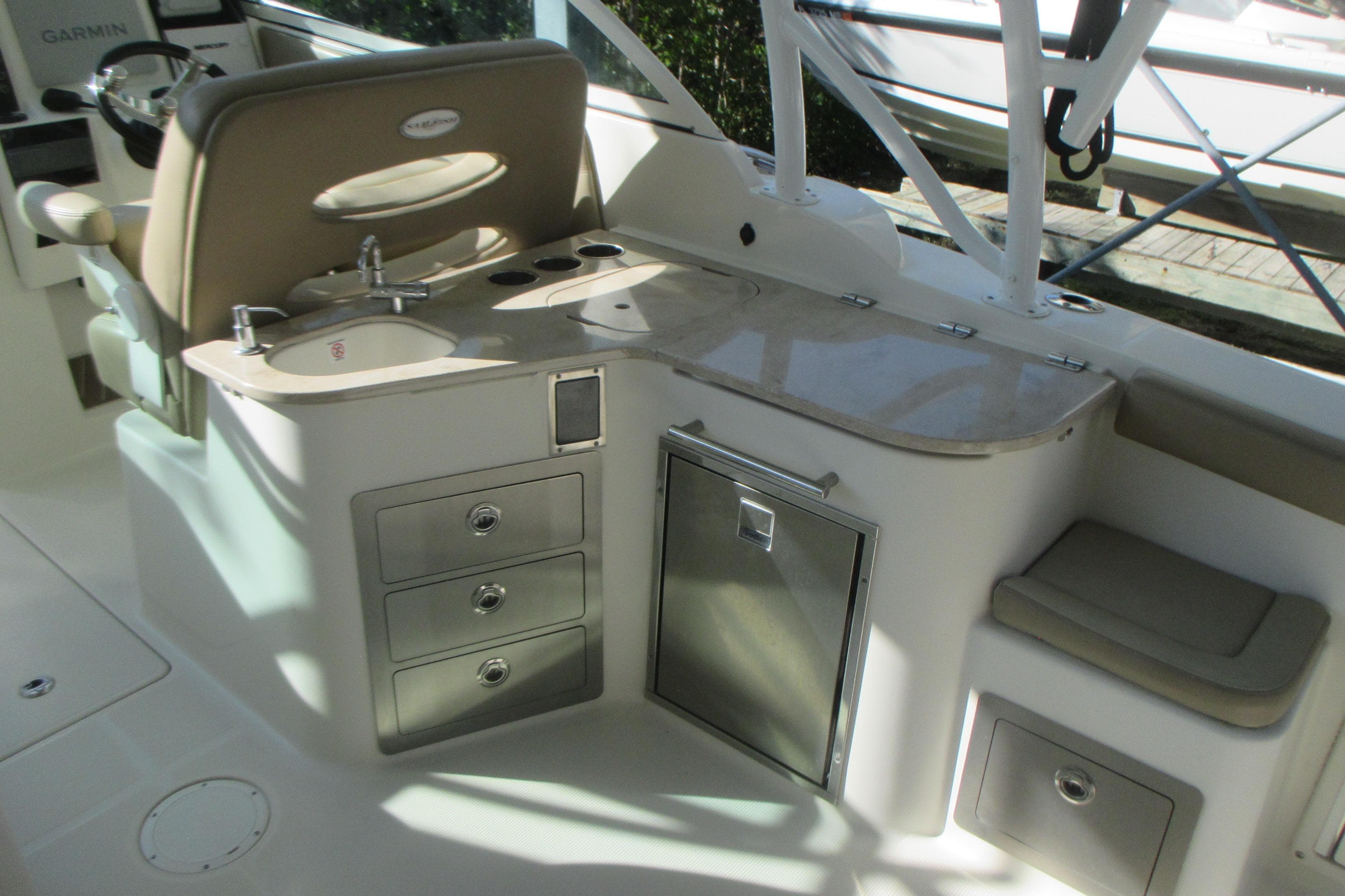 2019 Sailfish 325 DC boat interior with sink, storage drawers, and seating area.