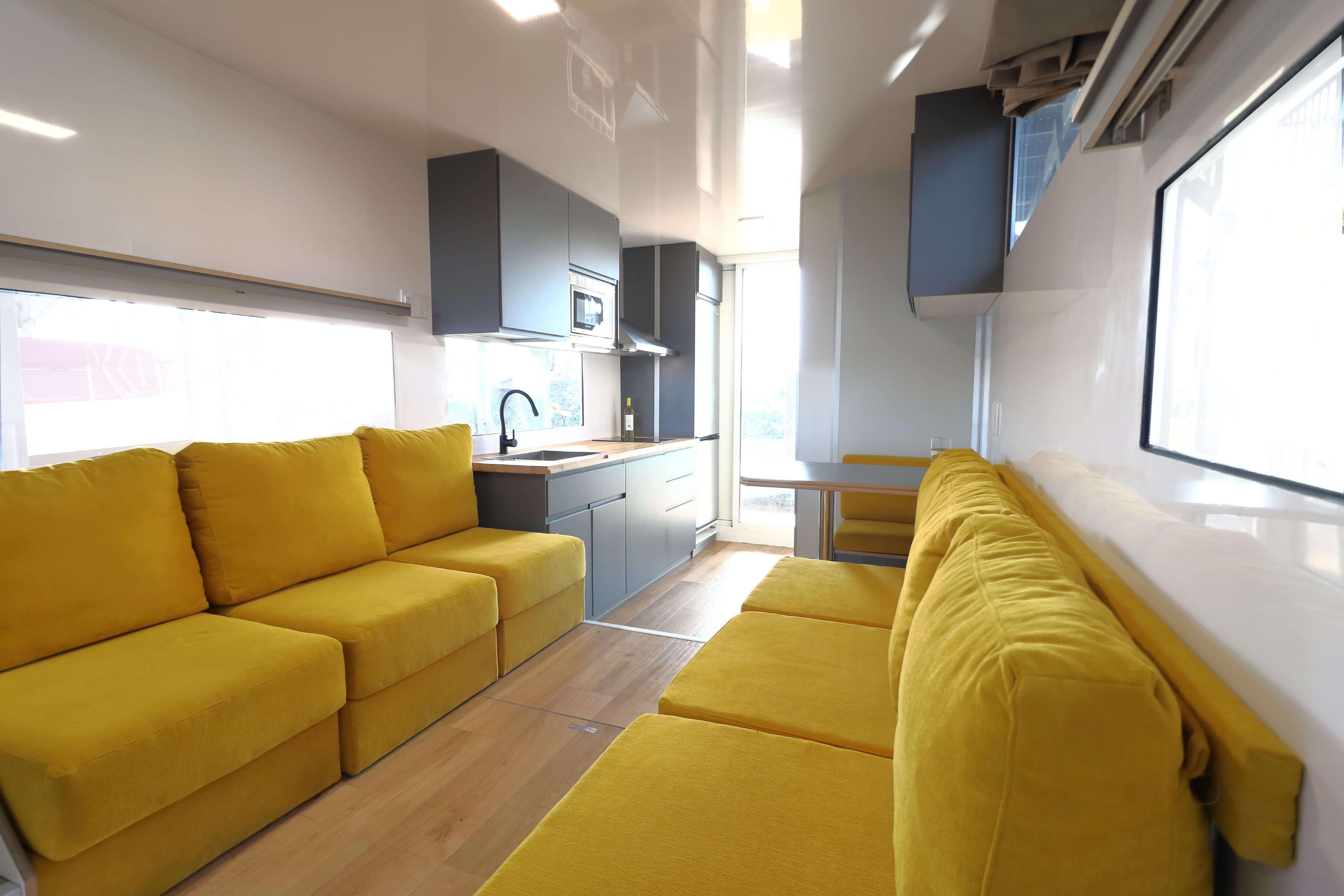 Modern Navisyo Homes NV.08 interior with yellow sofas and sleek kitchen, 2021 model.