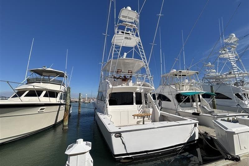 2007 Viking 52 Convertible yacht docked at marina under clear blue sky.
