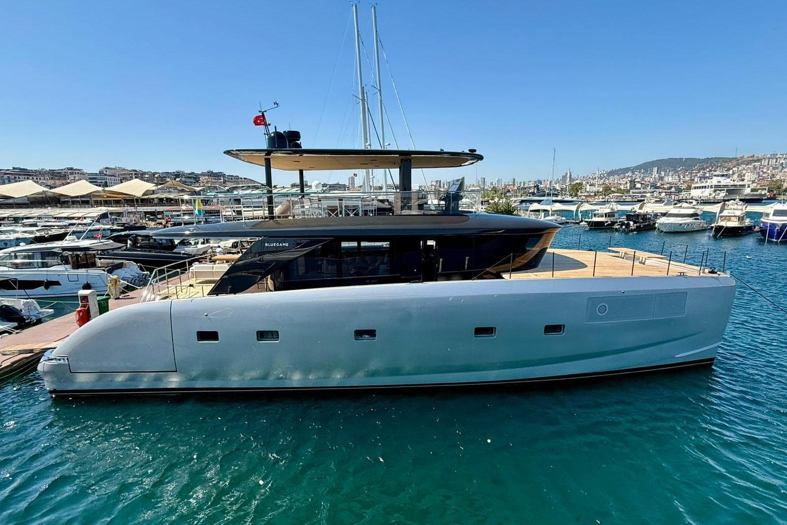 Luxury Bluegame BGM75 yacht docked in marina, 2025 model, sleek design, sunny day.