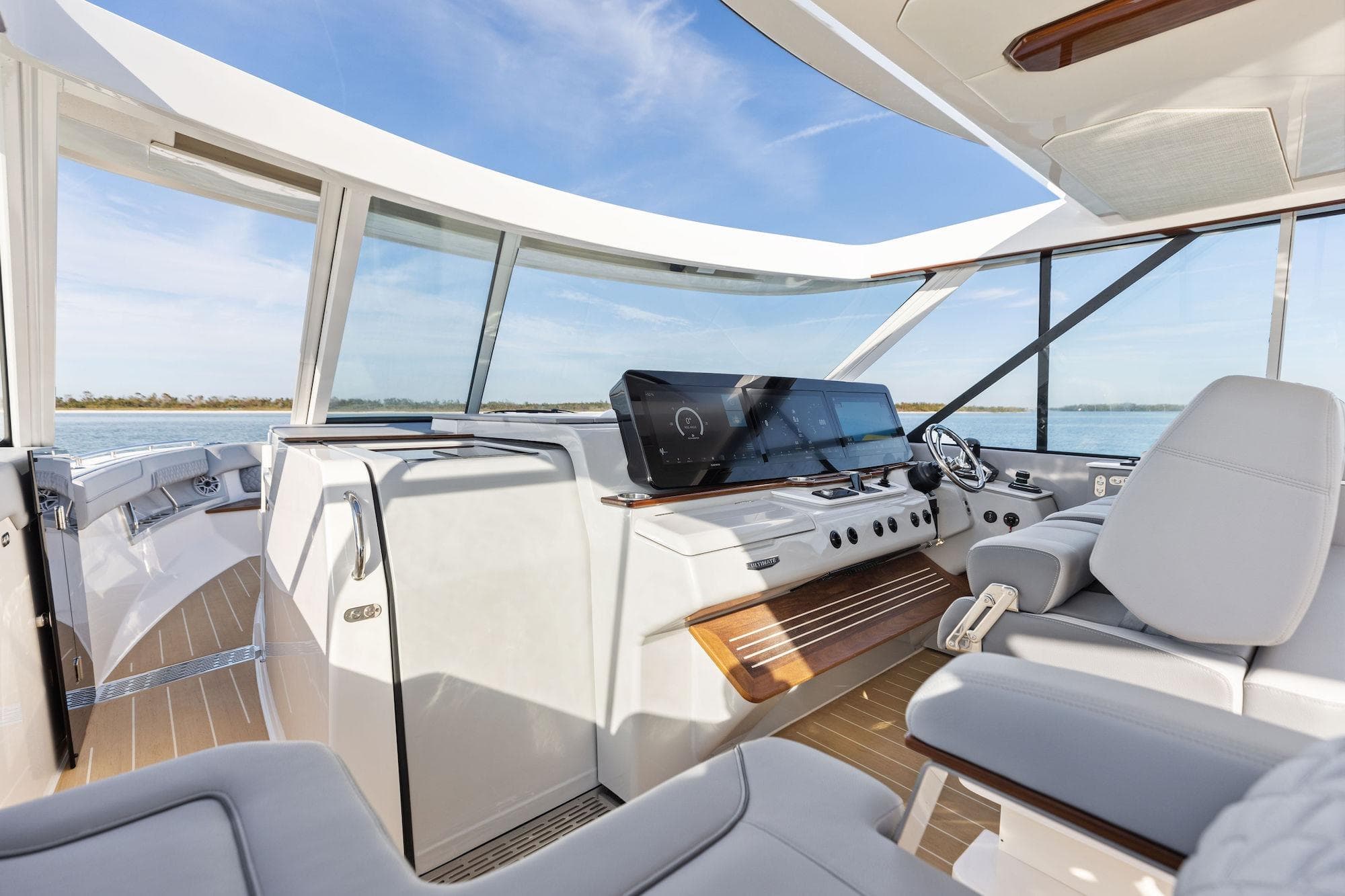 Luxurious 2026 Regal LX43 yacht interior with modern helm and panoramic windows.