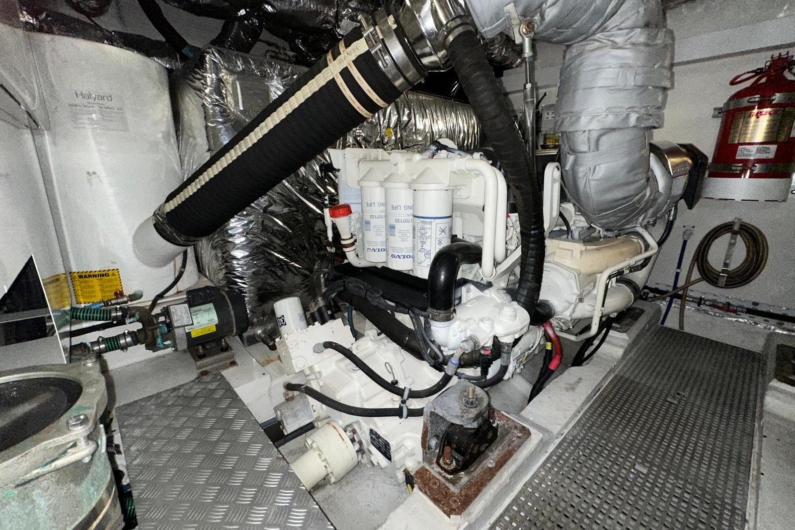 Engine room of a 2015 Princess 52 yacht, featuring mechanical components and fire safety equipment.