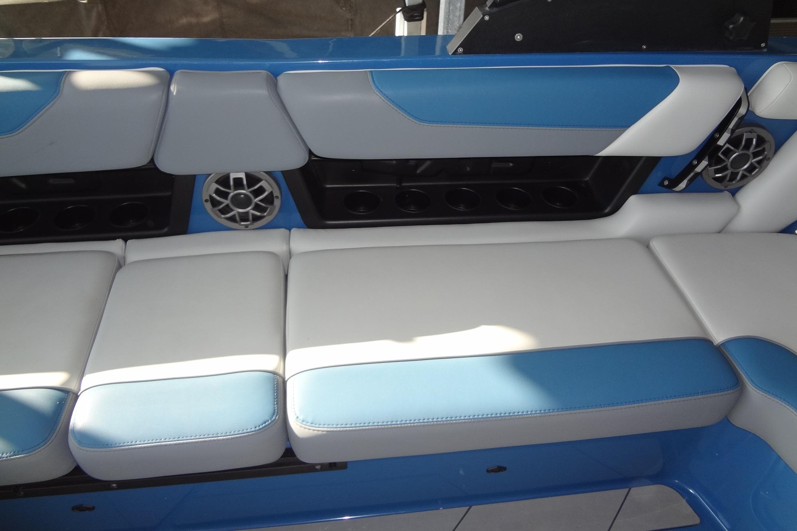 2021 Axis A24 boat interior with blue and white cushioned seating and built-in speakers.