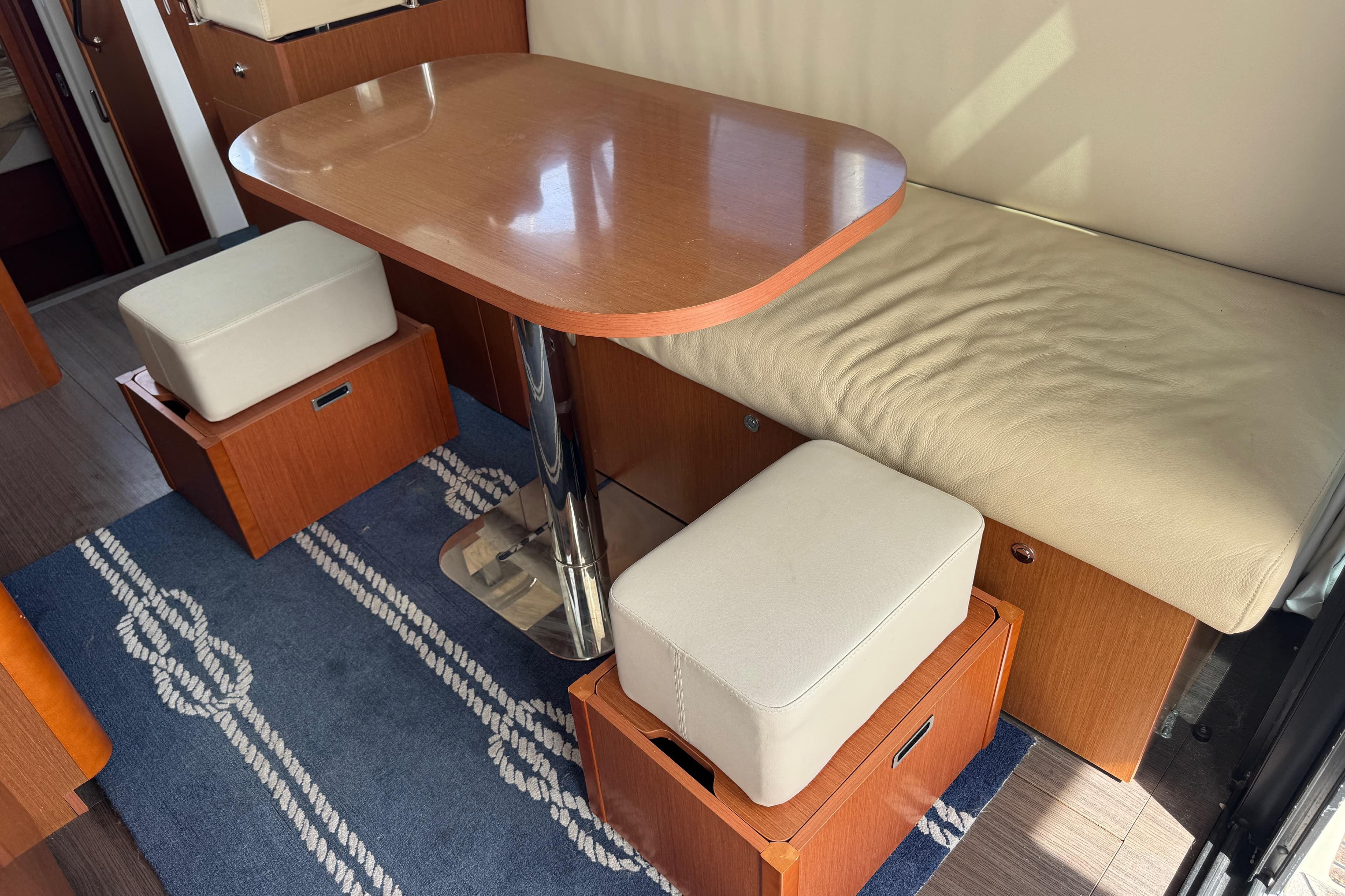 Interior of 2016 Beneteau Swift Trawler 30 with wooden table and cushioned seating.