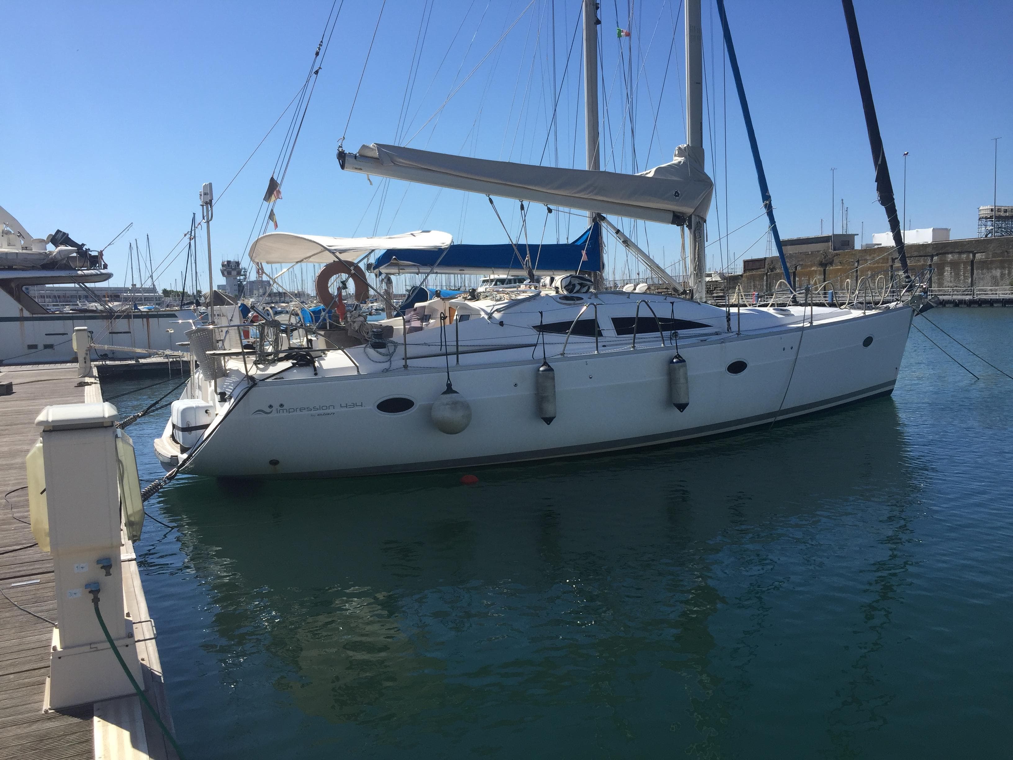 2005 Elan Impression 434 yacht docked at marina under clear blue sky.