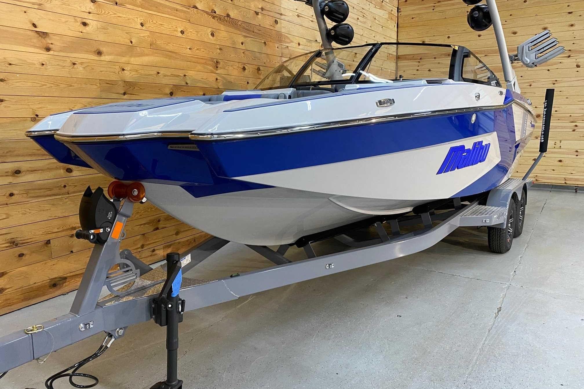 2024 Malibu Wakesetter 23 MXZ boat on trailer in wooden garage.