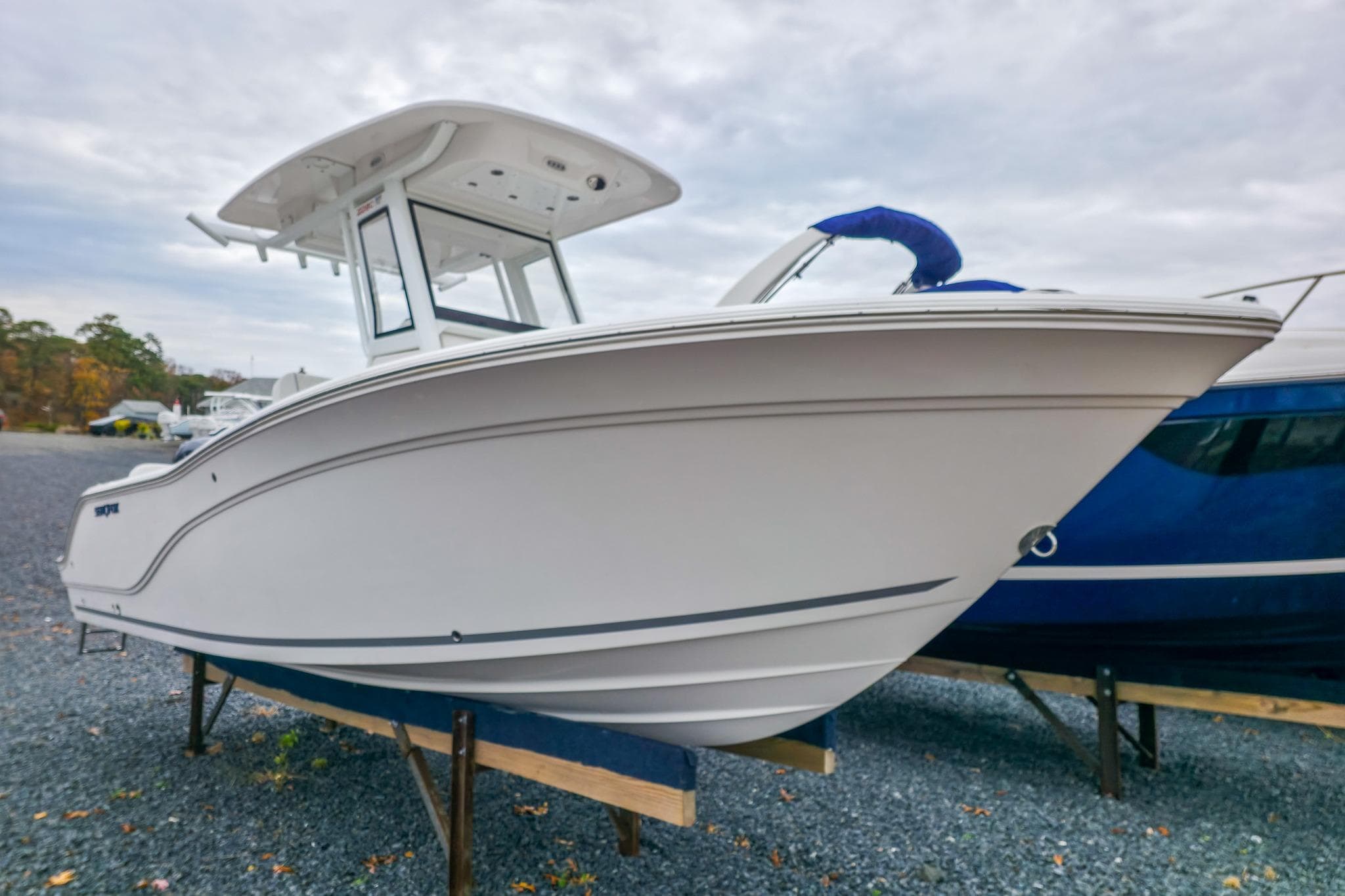 2026 Sea Fox 228 Commander boat displayed on gravel lot under cloudy sky.