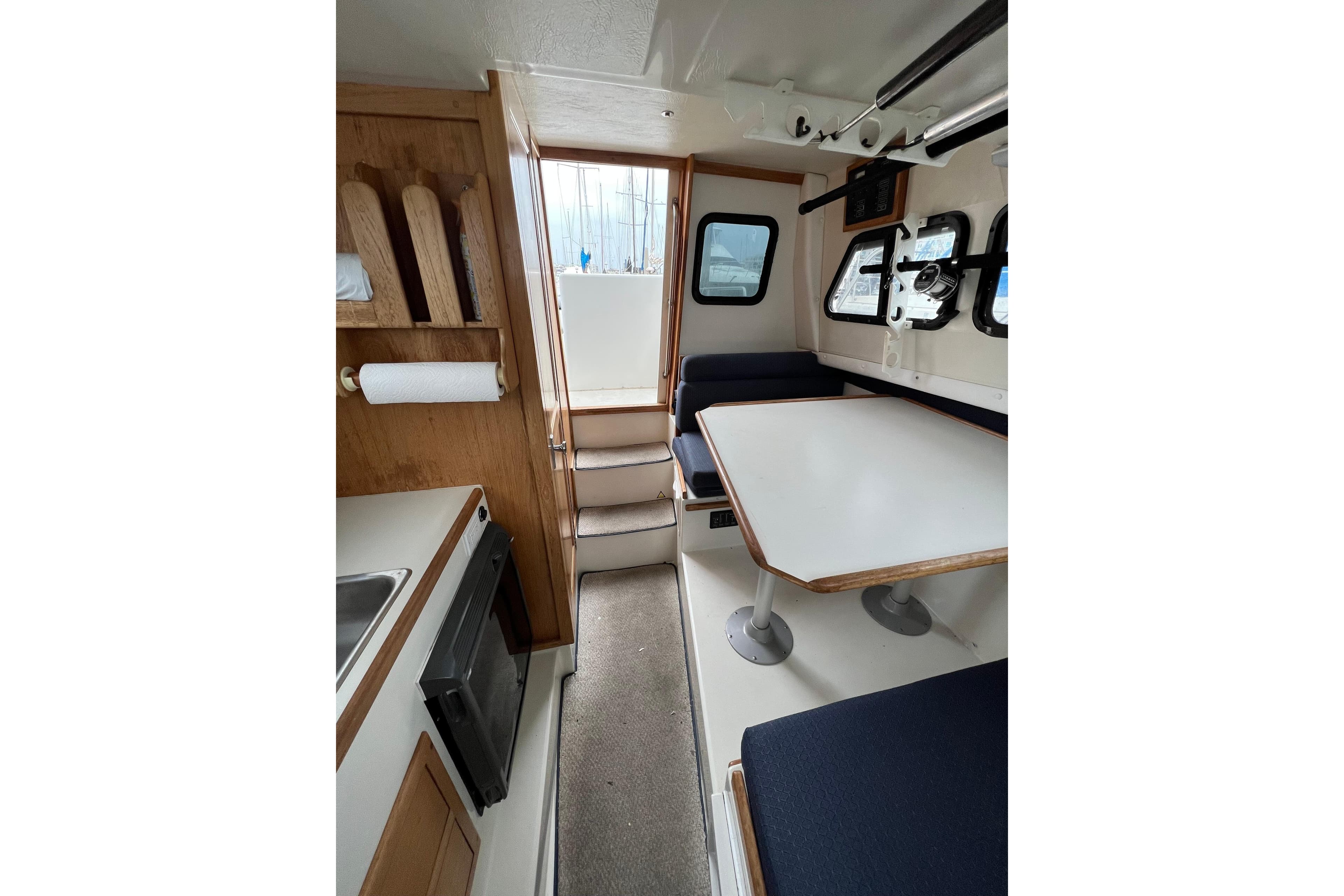 Interior of 2001 Skipjack 262 Flybridge boat with dining area and kitchenette.