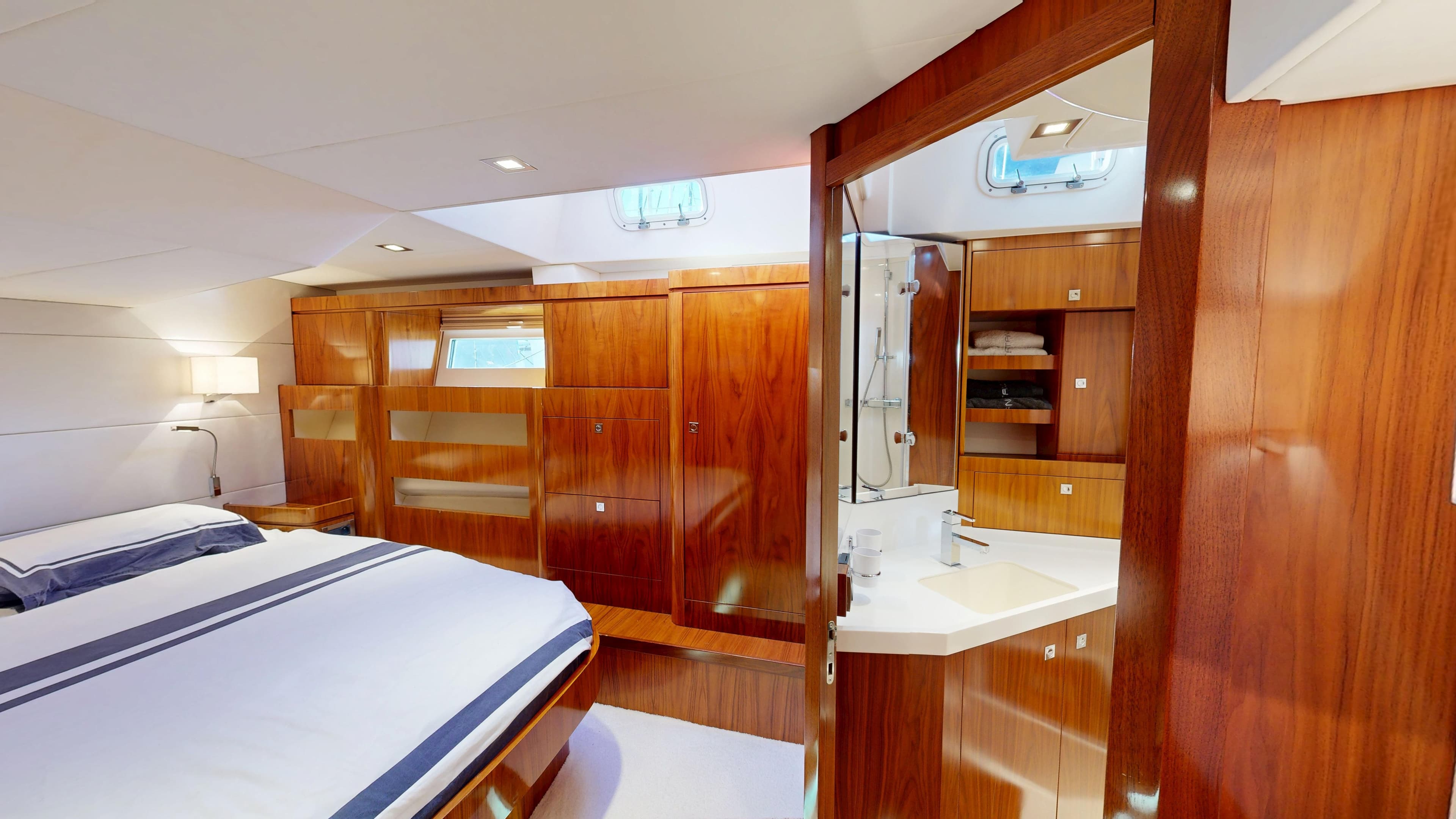 Luxurious Amel 64 yacht interior, featuring elegant wood finishes and a cozy bedroom, 2012 model.