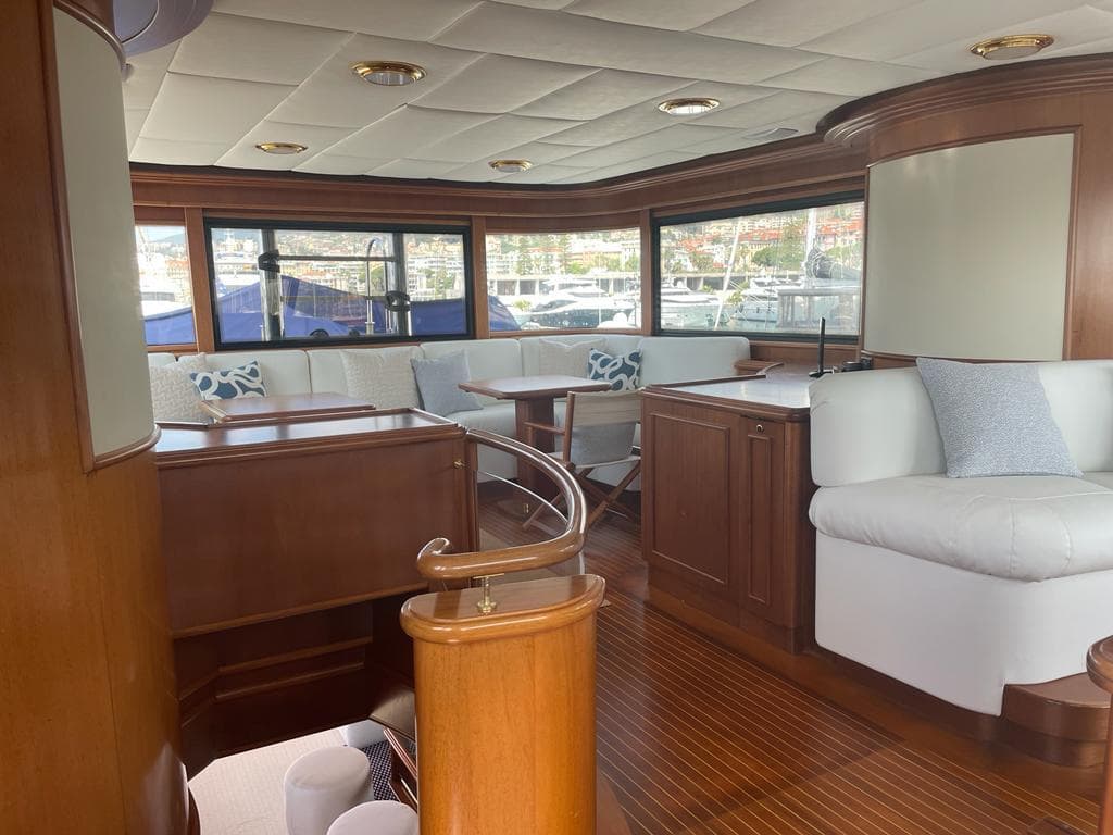 Luxurious interior of 2000 Custom Line Navetta 27m yacht with elegant wood and white furnishings.