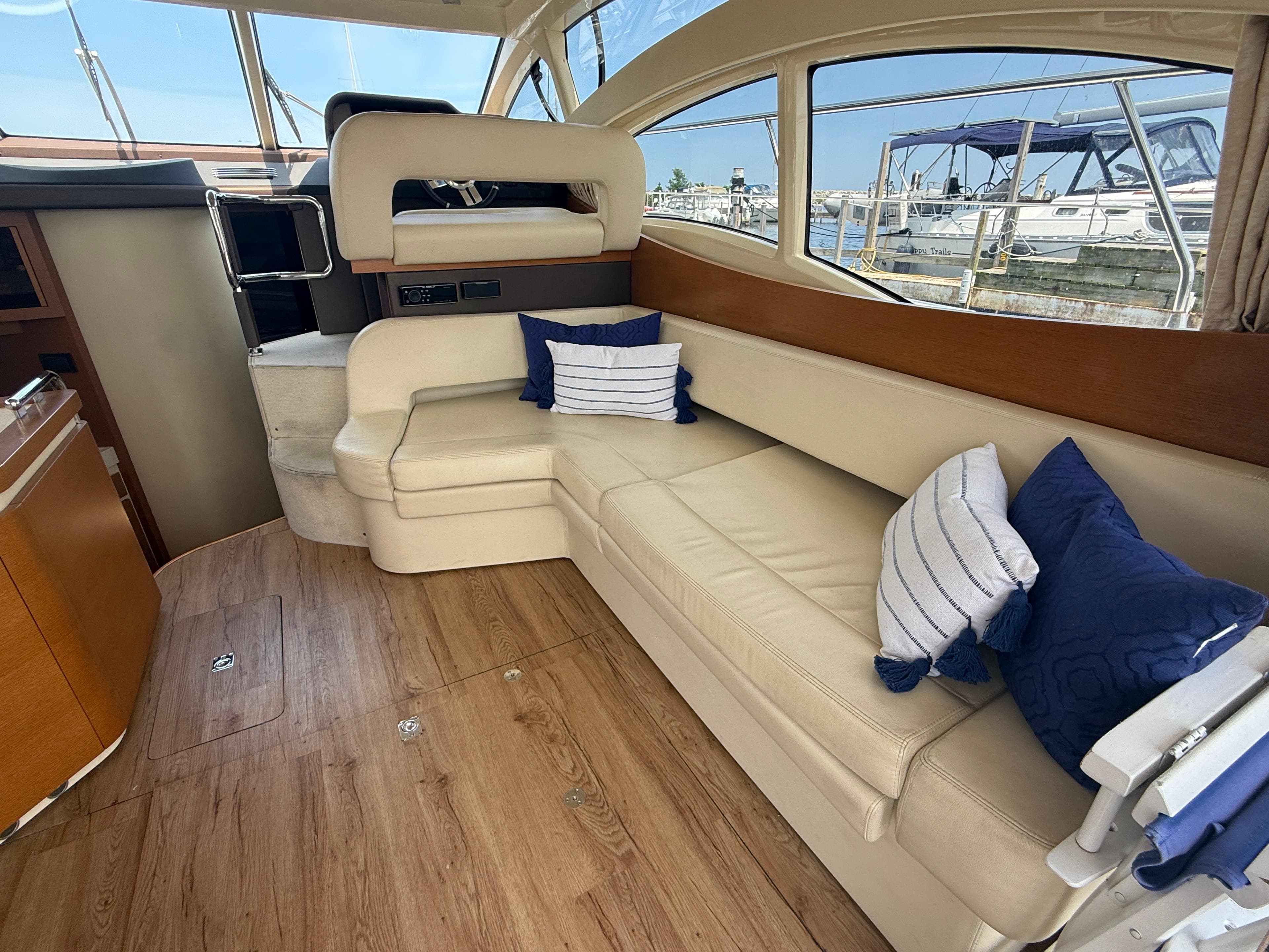 Interior of 2018 Azimut 42 Fly yacht with beige seating and blue cushions.