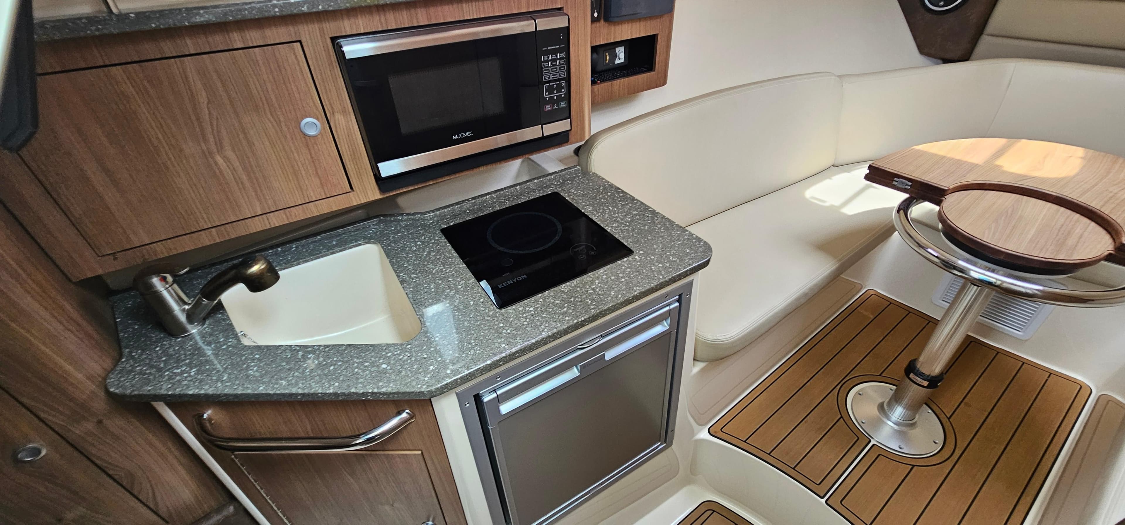 2016 Boston Whaler 285 Conquest interior with kitchenette and seating area.