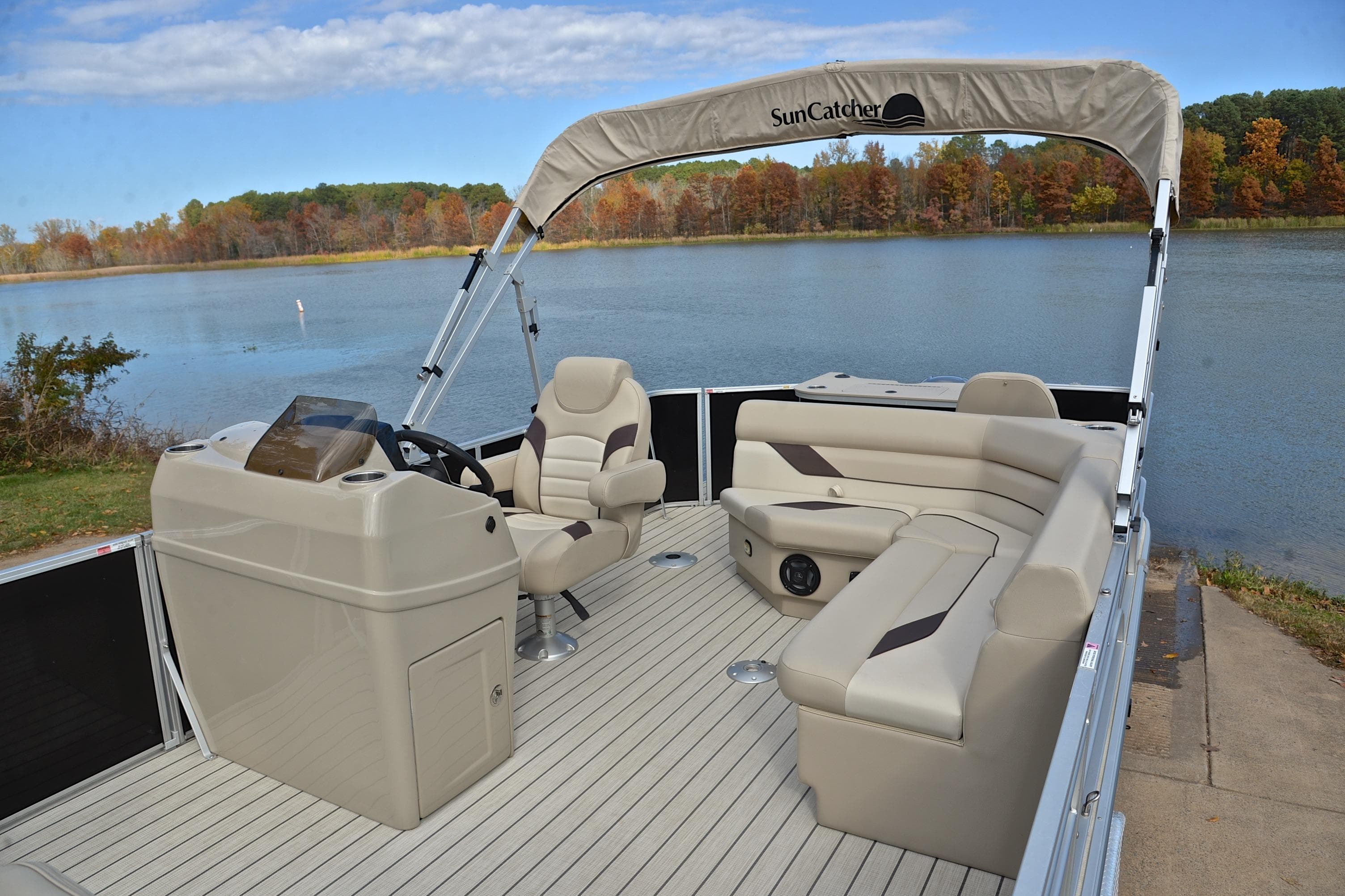 2023 SunCatcher Select 22F pontoon boat interior by a scenic lake.
