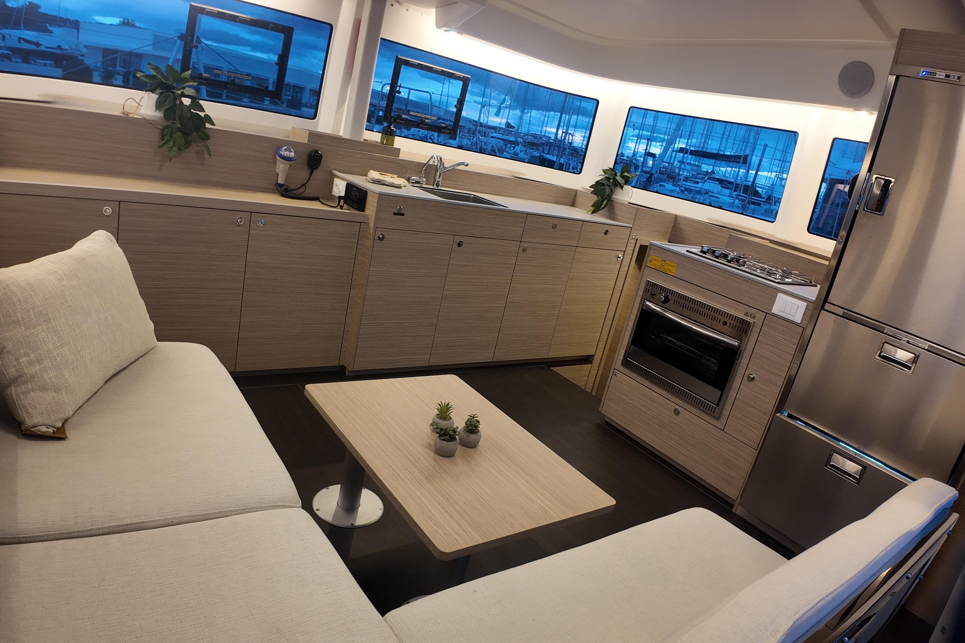 Modern interior of 2026 Lagoon 38 yacht with kitchen and seating area.