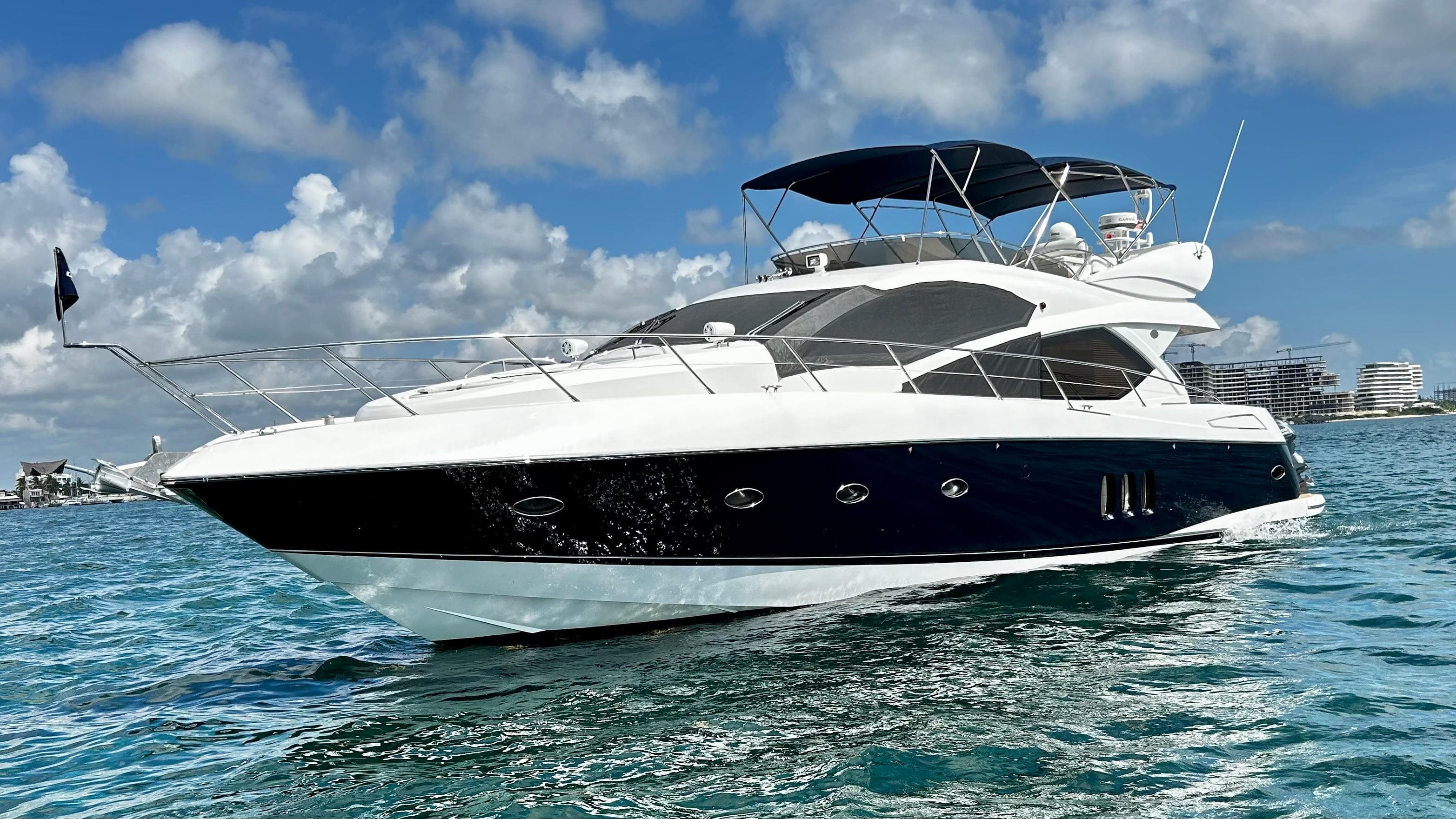 2006 Sunseeker Manhattan 60 yacht cruising on clear blue water under a partly cloudy sky.