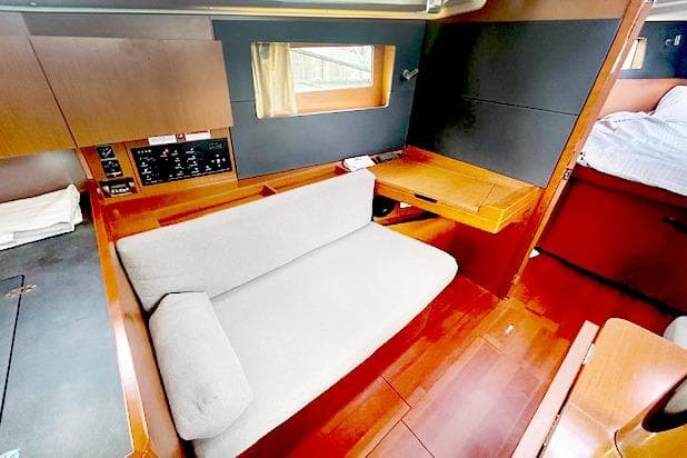 Interior of 2017 Beneteau Oceanis 41.1 yacht with wooden furnishings and cozy seating area.