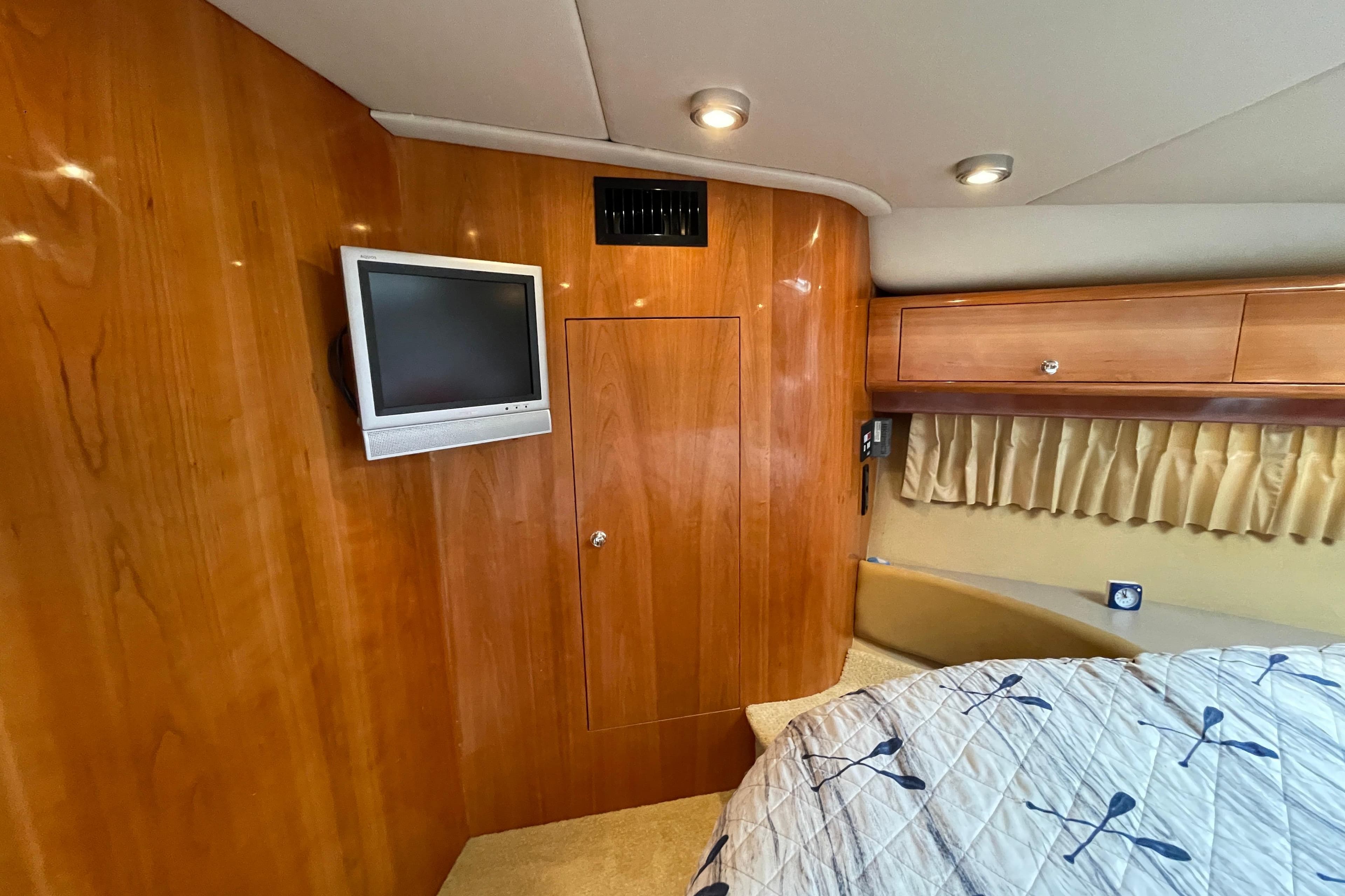 2004 Regal Commodore 4260 cabin interior with wood paneling, TV, and bed.