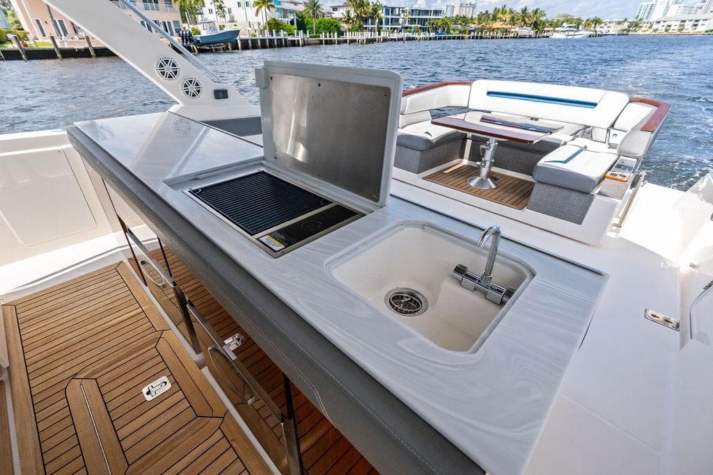 Luxury 2021 Tiara Yachts 43 LS with outdoor kitchen and seating area by the water.
