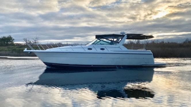 1997 Tiara Yachts 4000 Express cruising on calm water at sunset.