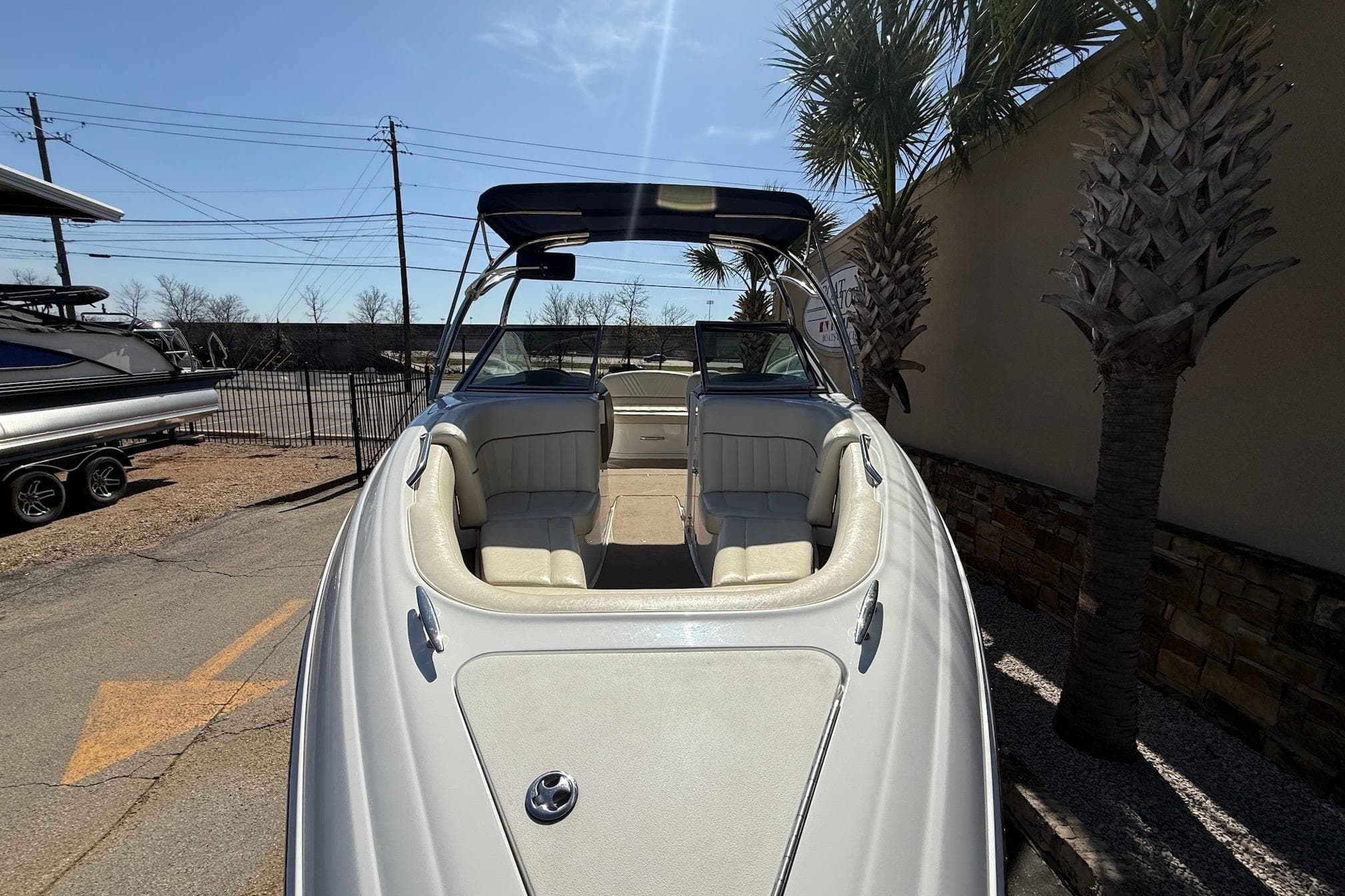 2009 Cobalt 242 boat with white interior, parked outdoors under a clear sky.