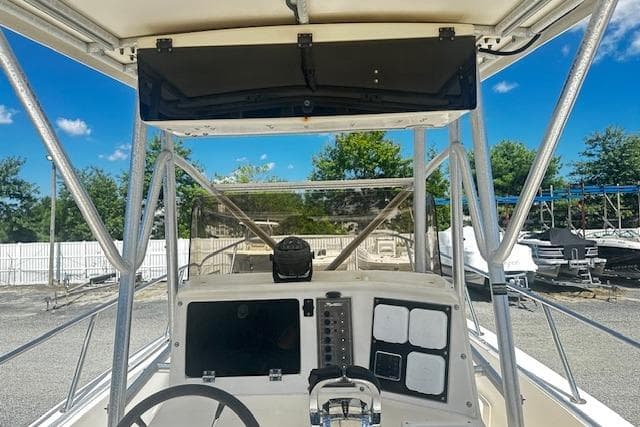 1997 Sea Cat Catamaran helm with steering wheel and control panel, docked outdoors.