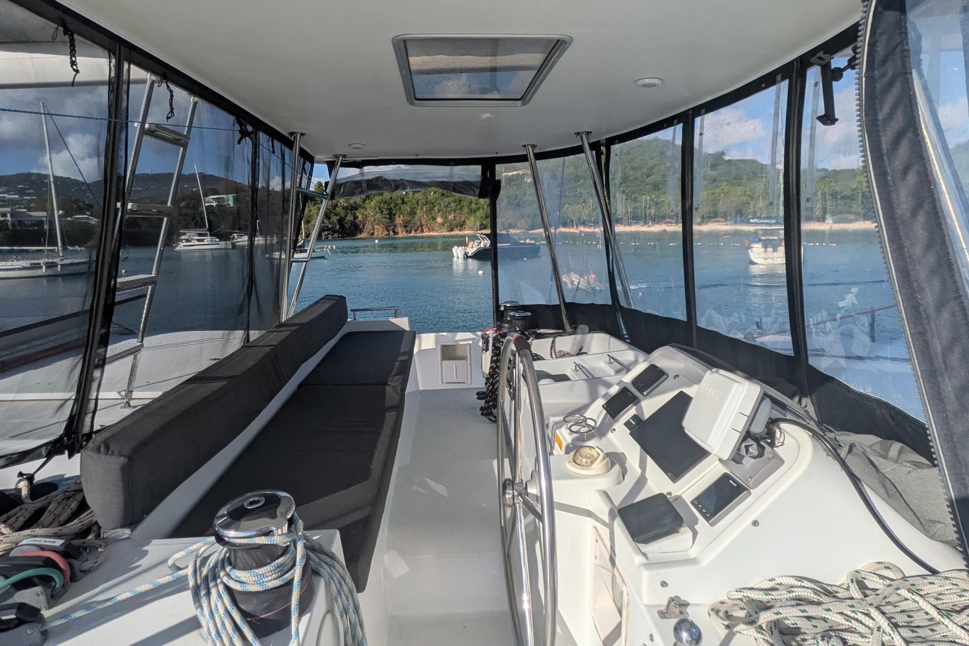 Interior view of 2012 Lagoon 450 catamaran with helm and seating, overlooking serene waters.