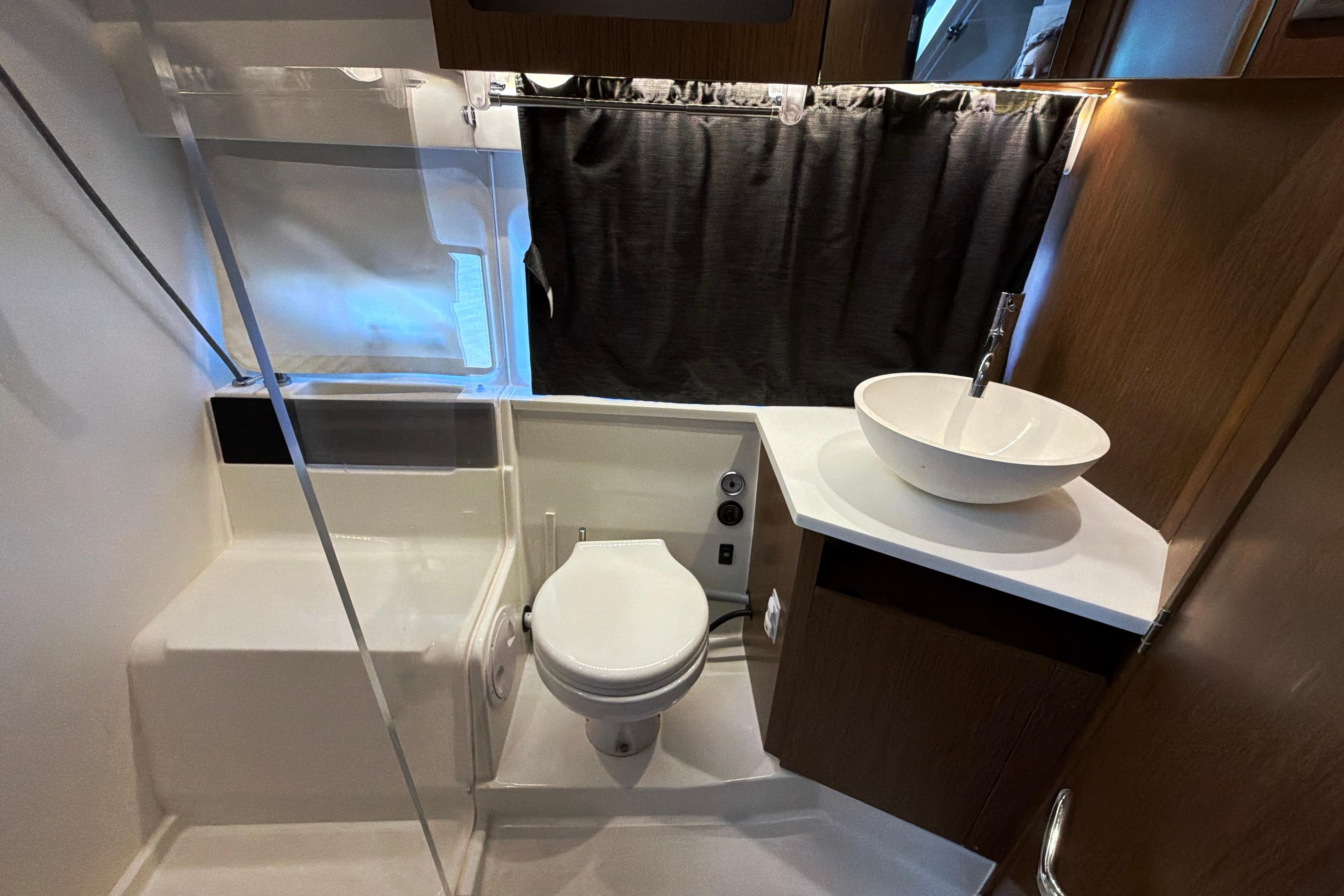 Modern bathroom interior of 2023 Beneteau Antares 11 yacht with sink and toilet.