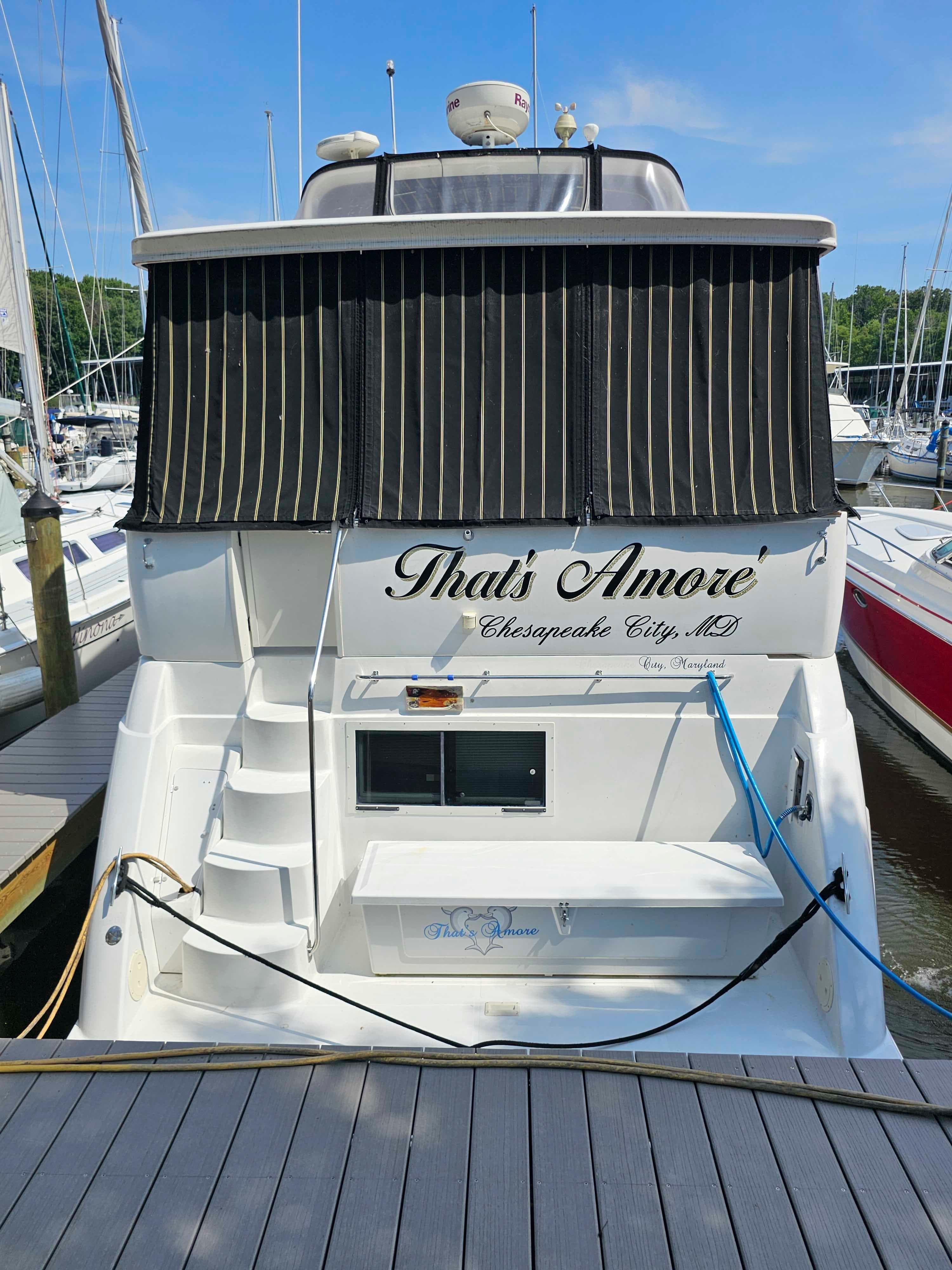 Carver 356 Aft Cabin Motor Yacht 2000 docked, rear view with "That's Amore" name.
