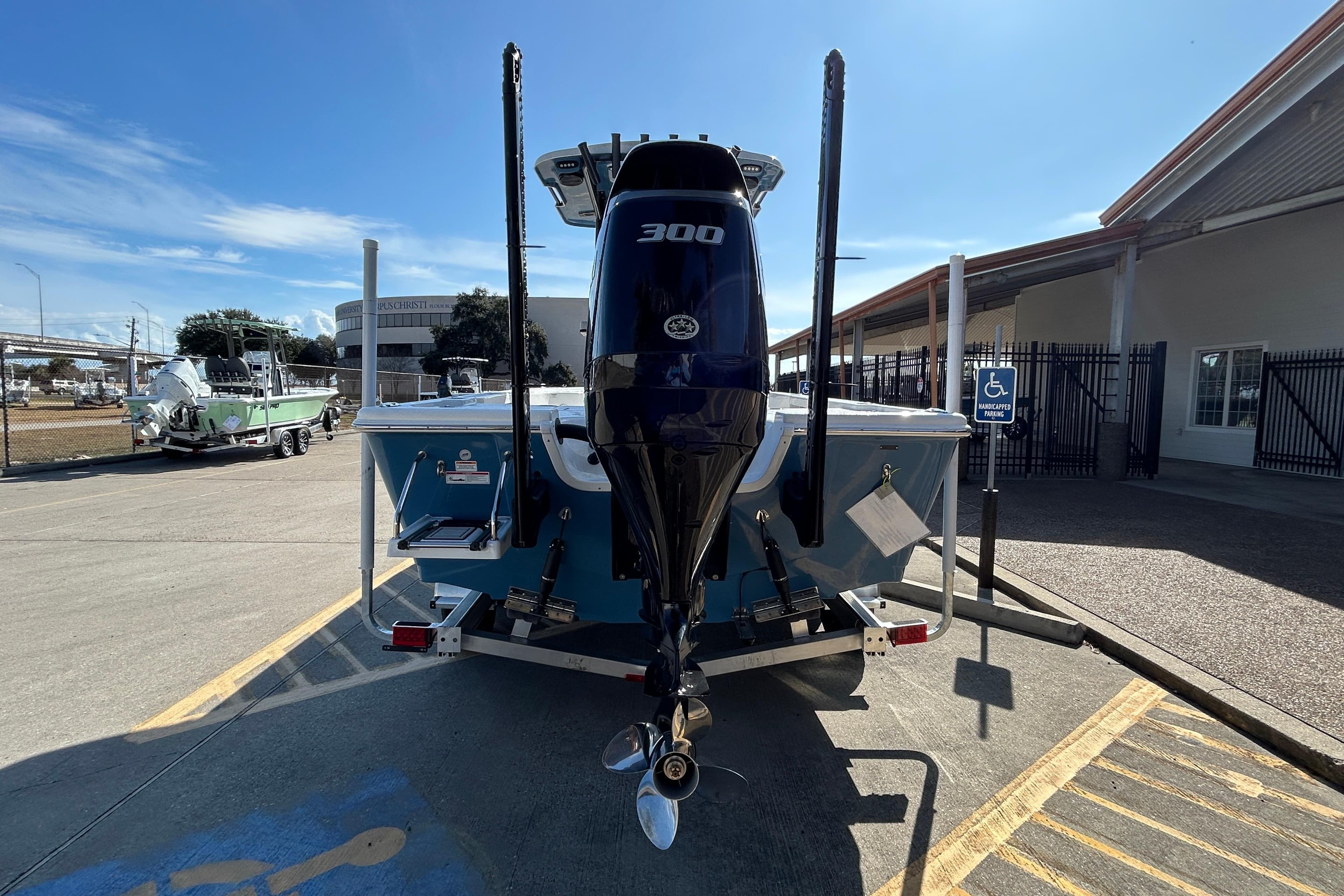2026 Sea Pro 250 Bay boat with 300 horsepower engine, parked outdoors.