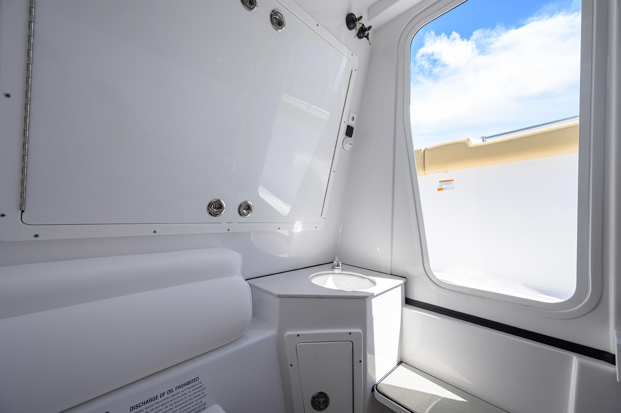 Interior of 2026 Sportsman Open 302 Center Console boat, featuring a compact sink and window.