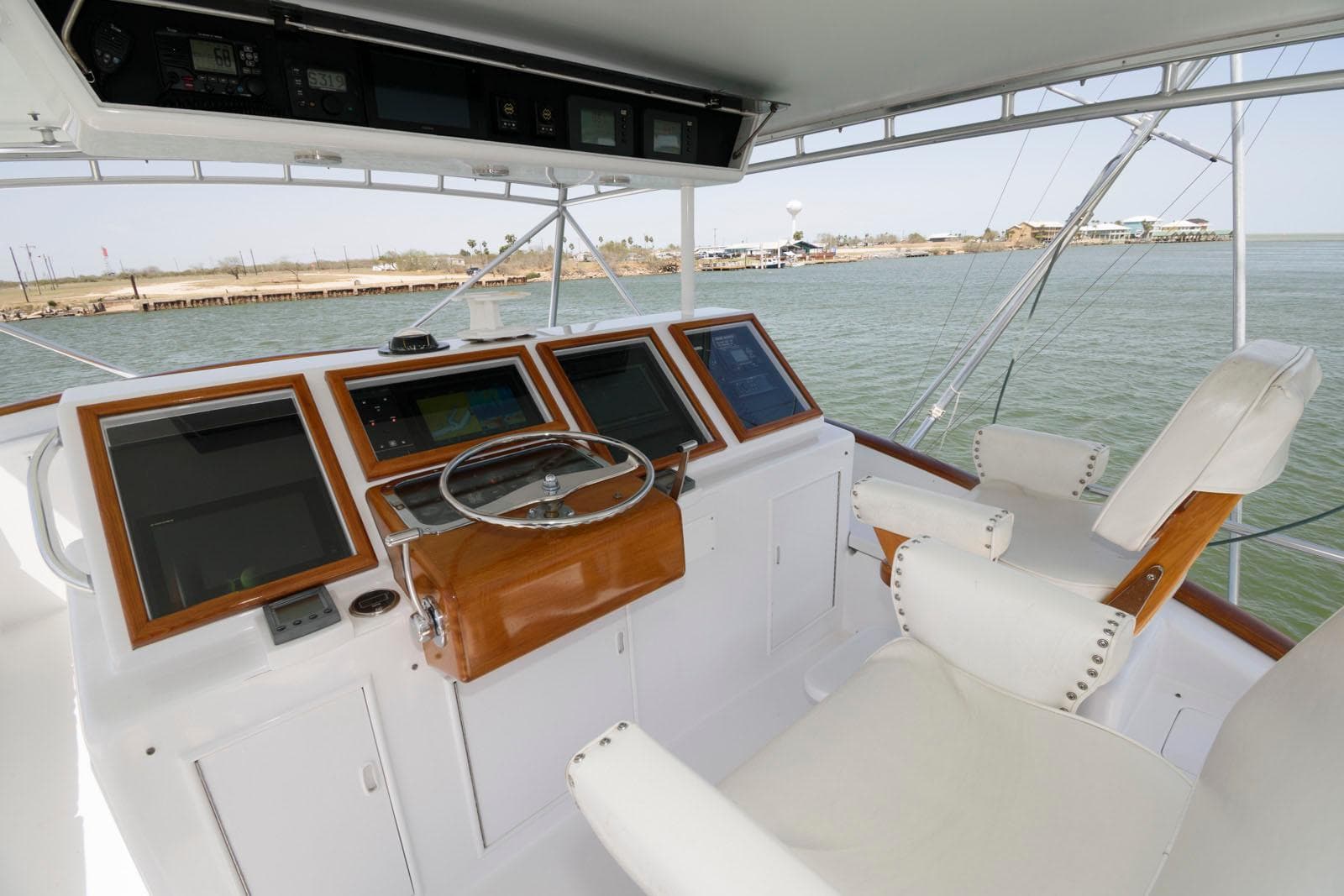 Helm of 1998 Huckins 70 Sportfish Convertible with navigation equipment and seating.