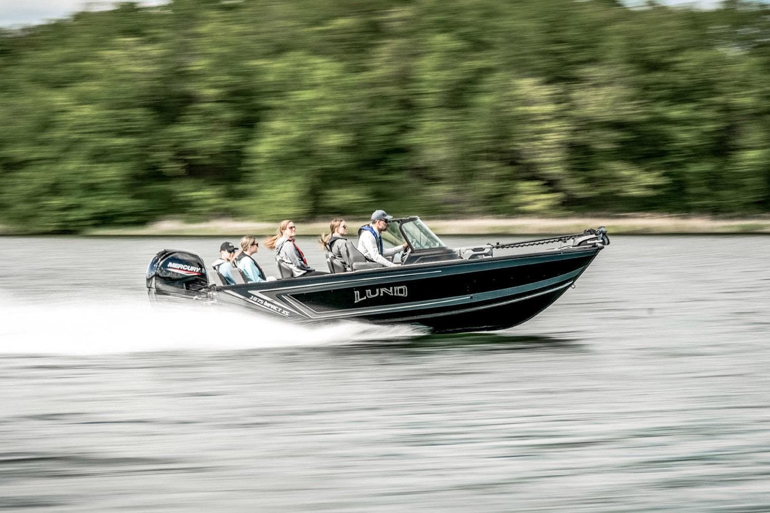 Manufacturer Provided Image: 2025 Lund 1875 Impact XS Sport boat speeding on a lake with passengers.