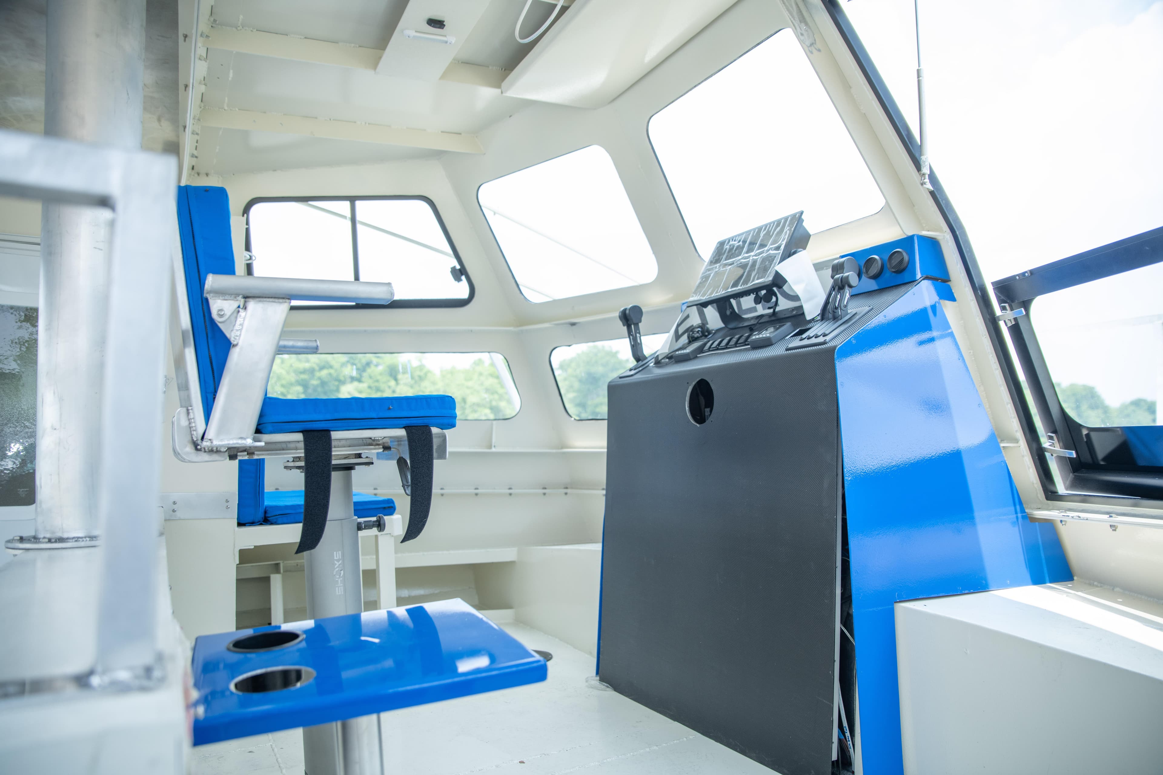 Interior of 2023 Smoky Mountain asymmetrical foil-assisted catamaran, featuring blue seating and control panel.