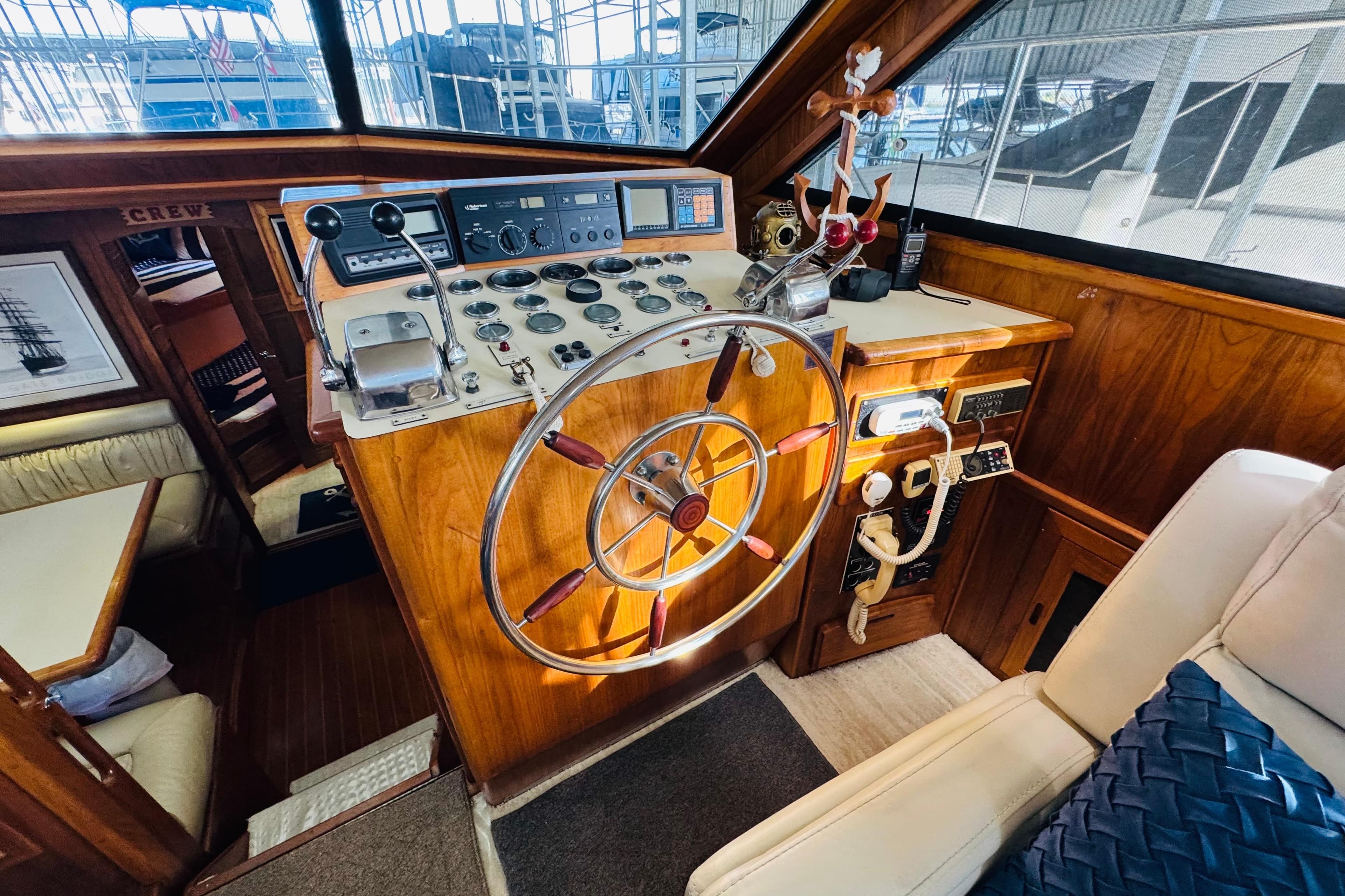 1986 Californian 48 Motor Yacht helm with classic wooden steering wheel and navigation controls.