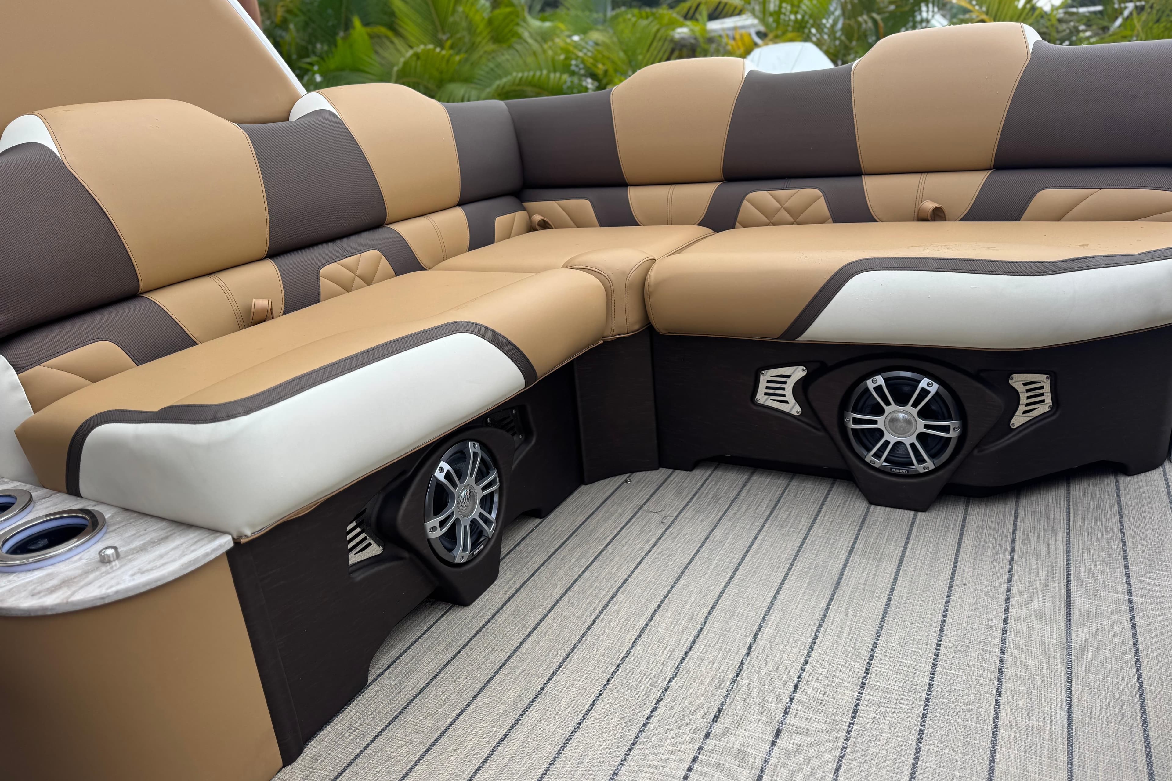 Luxurious seating on 2026 Avalon Excalibur 27' boat with integrated speakers and cup holders.