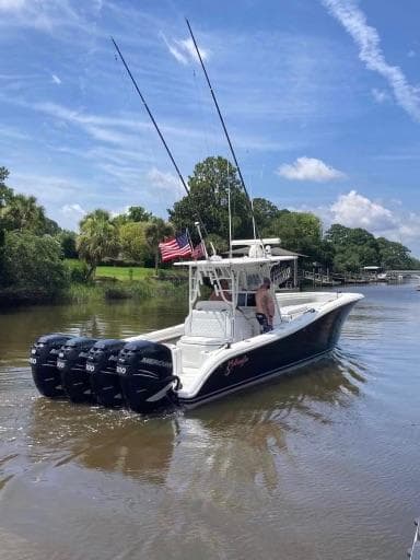 2007 Yellowfin 36 boat with triple outboard motors cruising on a scenic river.