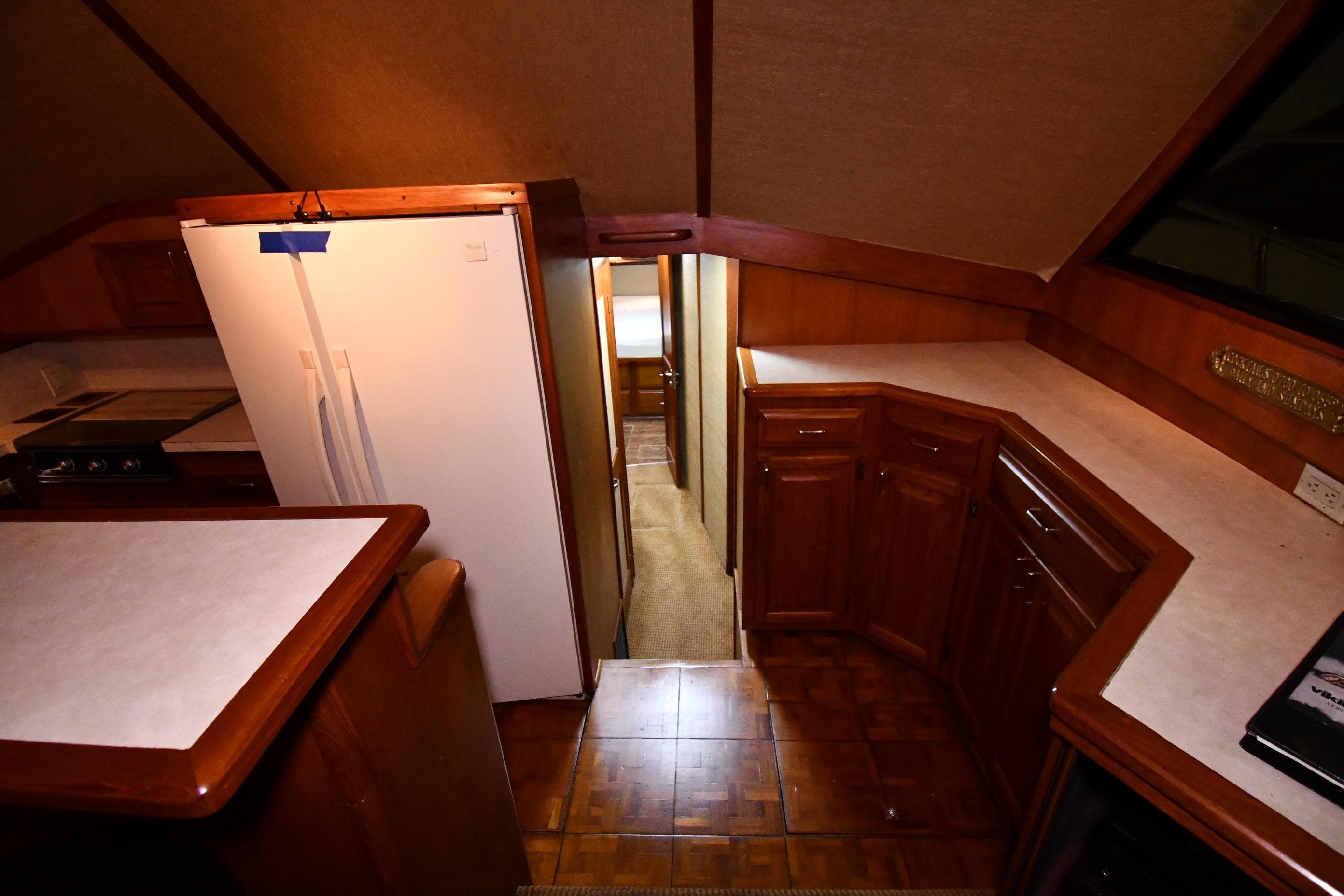 Interior of 1988 Viking 48 Convertible yacht with wooden cabinetry and white countertops.