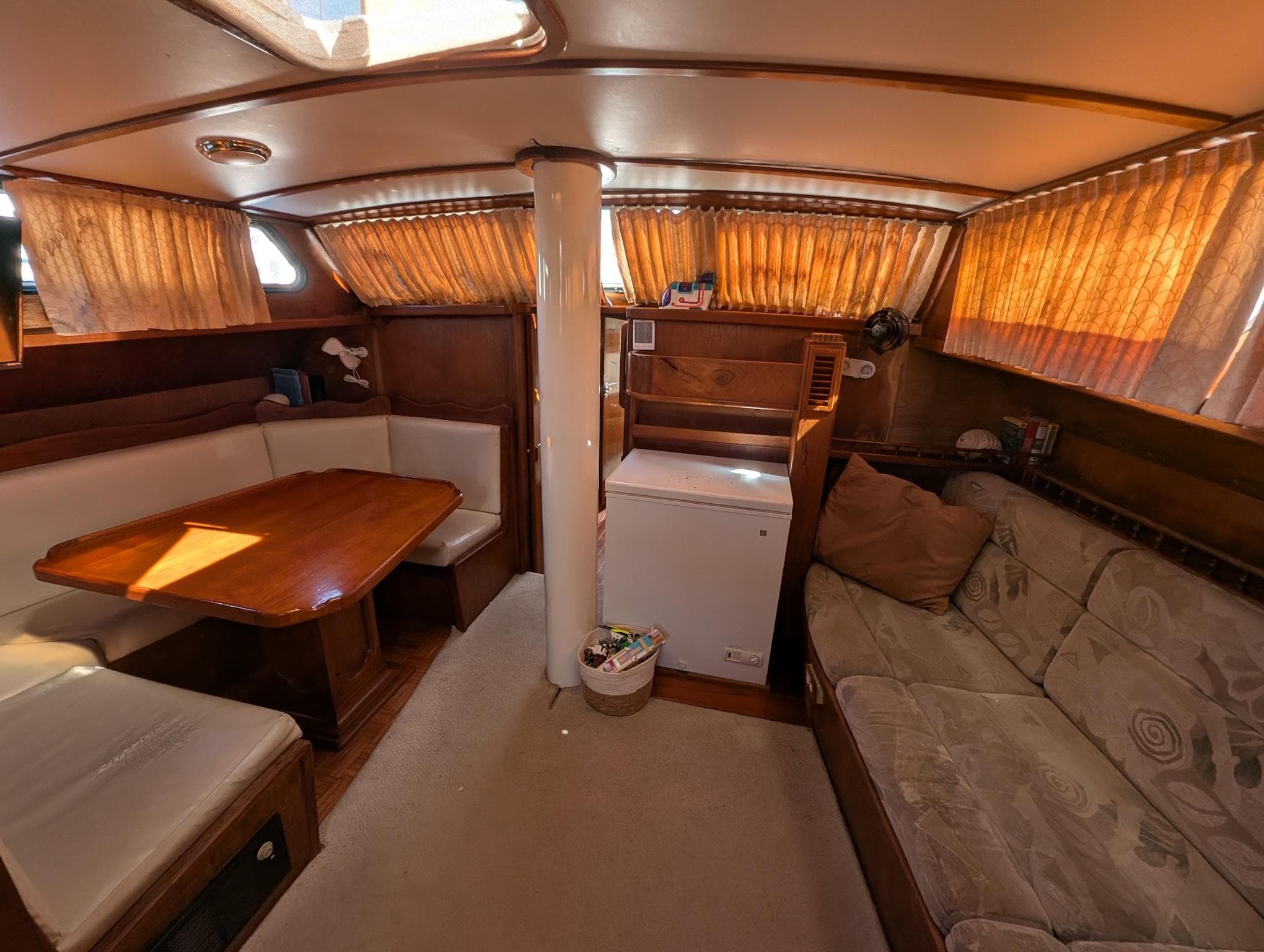 Interior of a 1973 Maple Leaf 48 yacht with cozy seating and wooden table.